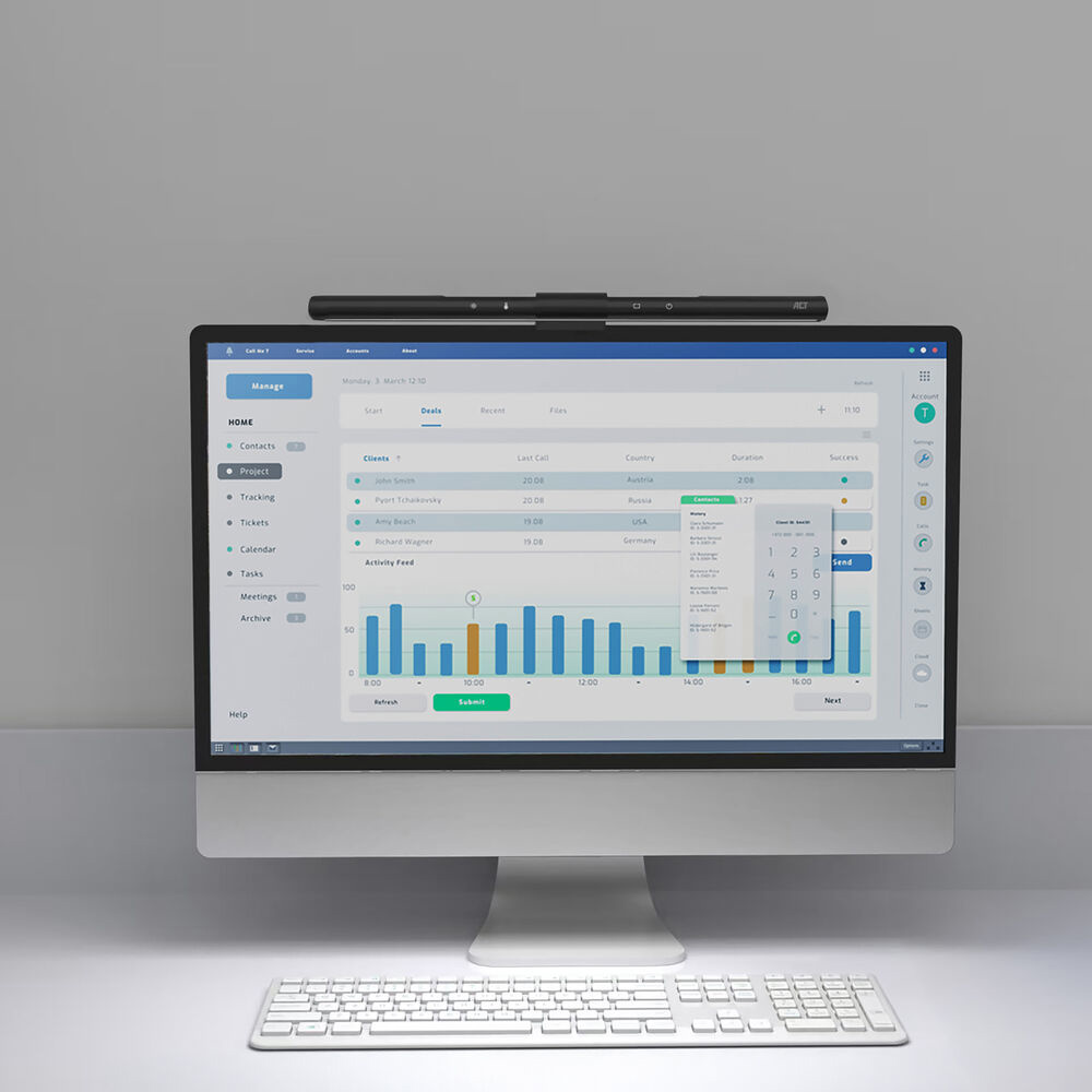 A computer monitor displays a business interface. A keyboard sits below. A light bar is above the screen.