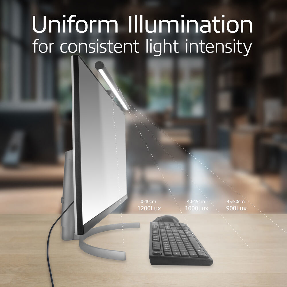A computer monitor with a desk lamp attached, illuminating the screen. A keyboard is in front, with light intensity details.
