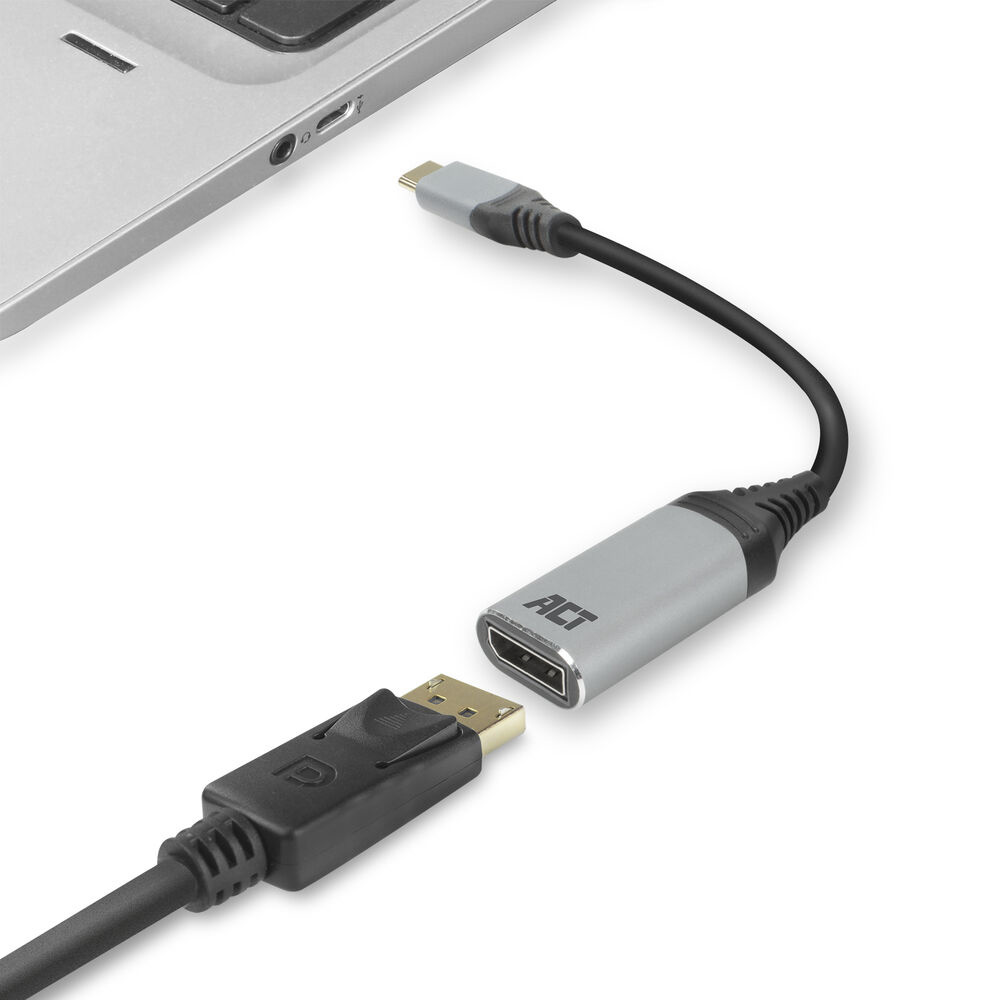 Un cavo adattatore grigio e nero con connettori DisplayPort e USB-C, accanto a un laptop.