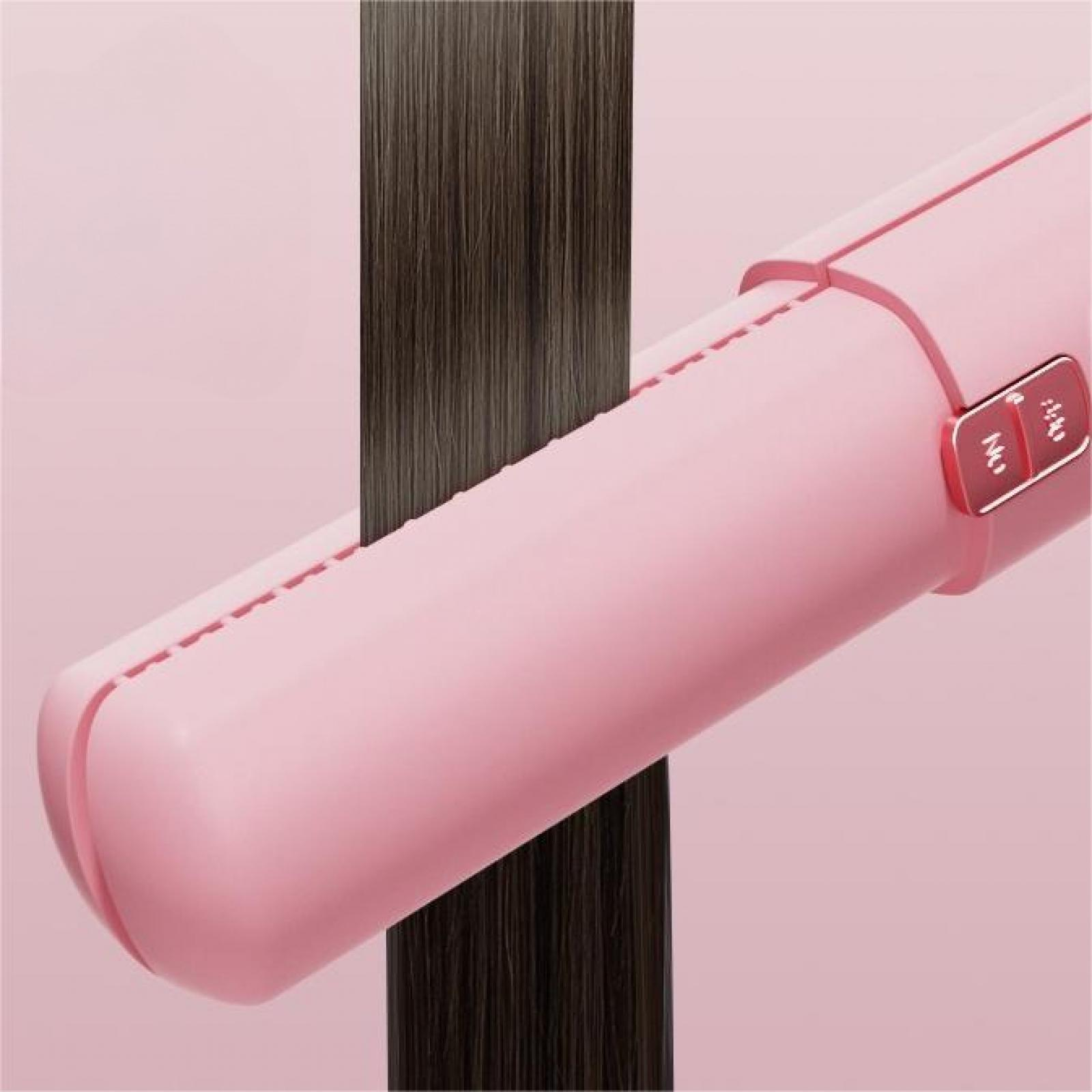 Pinkes Glätteisen mit dunkler Haarsträhne zwischen den Platten. Ein-/Ausschalter sichtbar. Pinker Hintergrund.