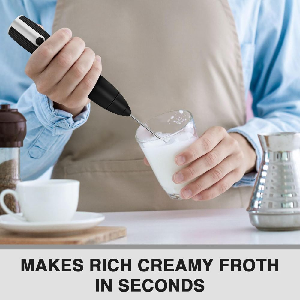 Eine Person schäumt Milch in einem Glas mit einem Handaufschäumer auf. Unten steht: ERZEUGT REICHHALTIGEN, CREMIGEN SCHAUM IN SEKUNDEN.