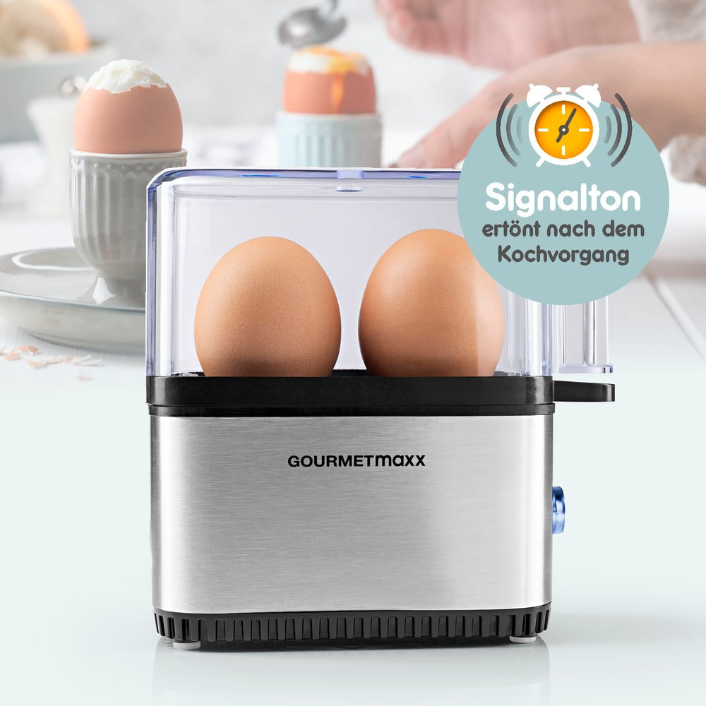 Gotowacz do jajek z dwoma brązowymi jajkami w środku. Dwa ugotowane jajka w tle, jedno w filiżance. Znak wskazuje sygnał końcowy.