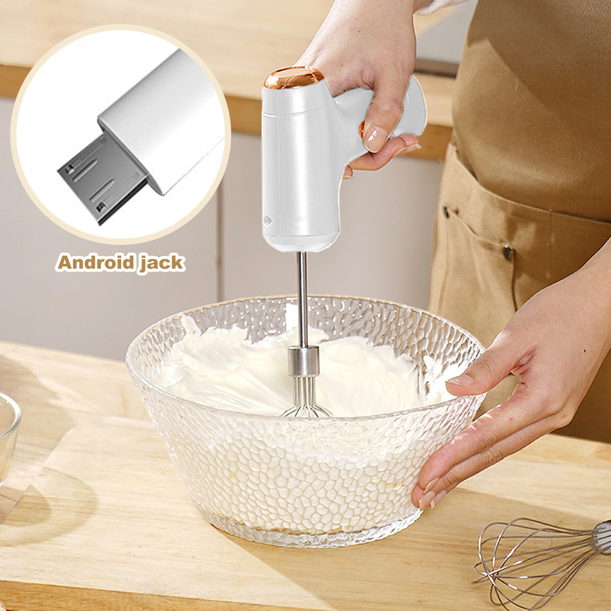 Eine Person verwendet einen weißen Handmixer, um Sahne in einer Glasschüssel zu verrühren. Ein Android-Anschluss ist sichtbar.