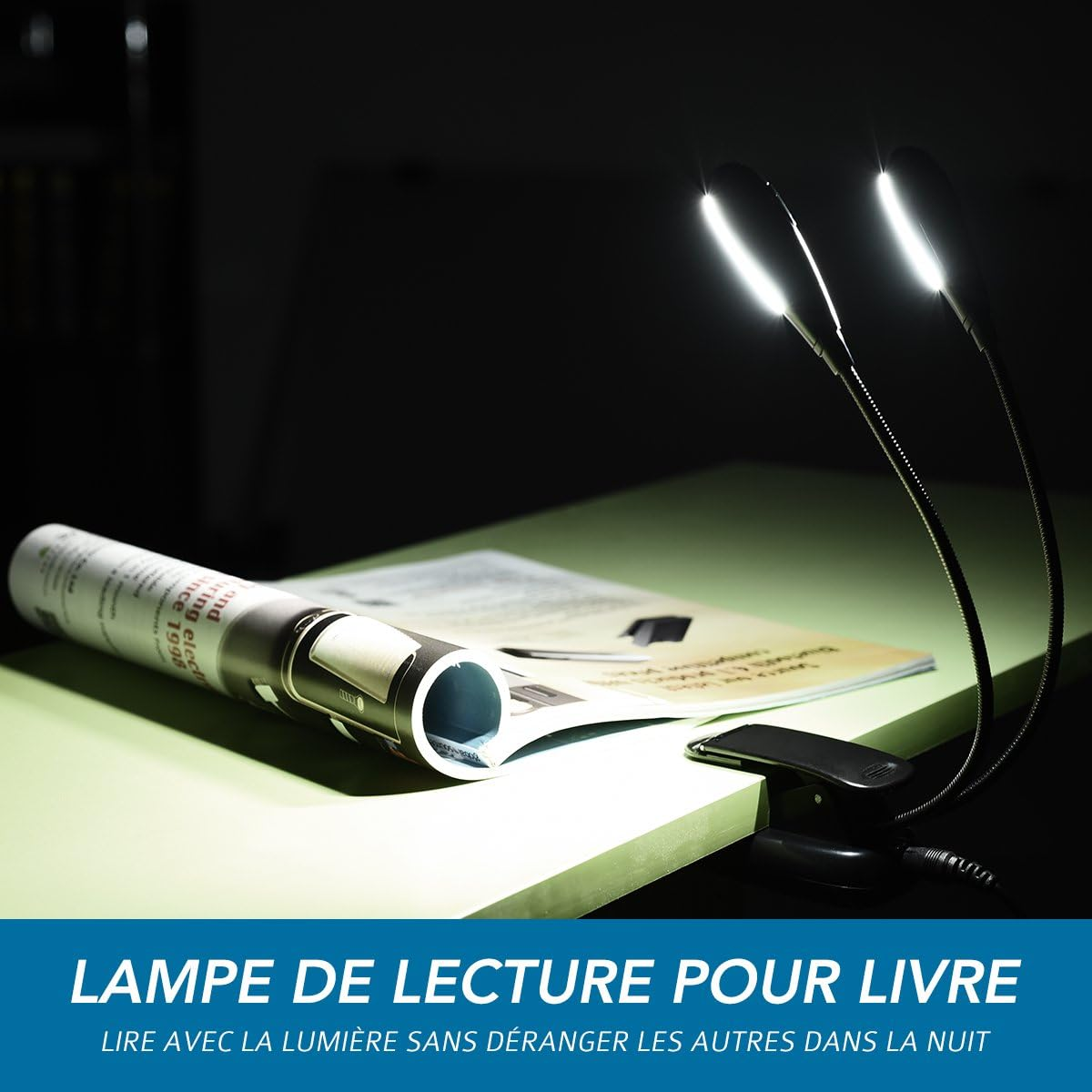 Eine Leselampe beleuchtet ein Buch auf einer grünen Oberfläche. Die Lampe hat zwei Lichter. Eine Zeitung ist ebenfalls vorhanden.
