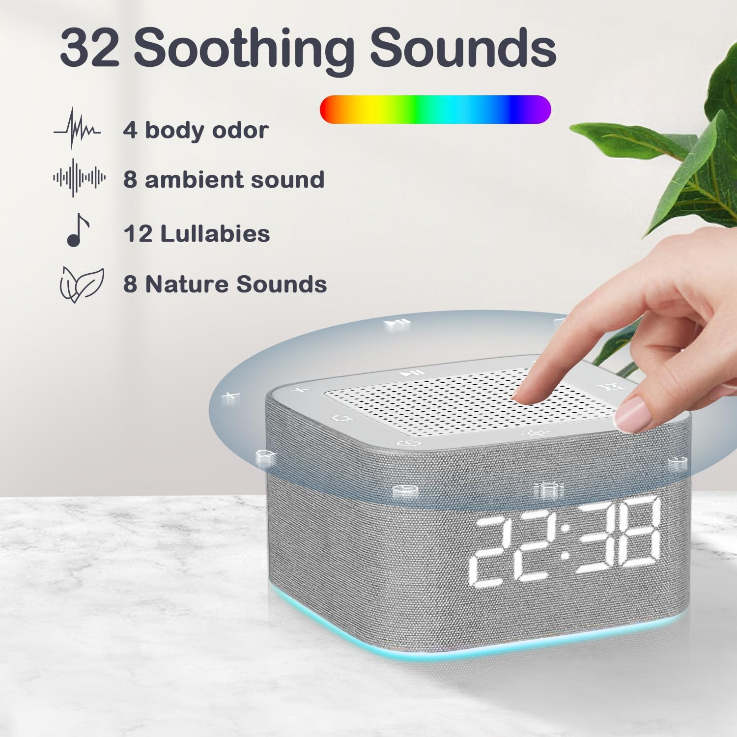 Graue Soundmaschine mit Digitaluhr zeigt 22:38. Eine Hand berührt die Oberseite. Text: 32 beruhigende Klänge.
