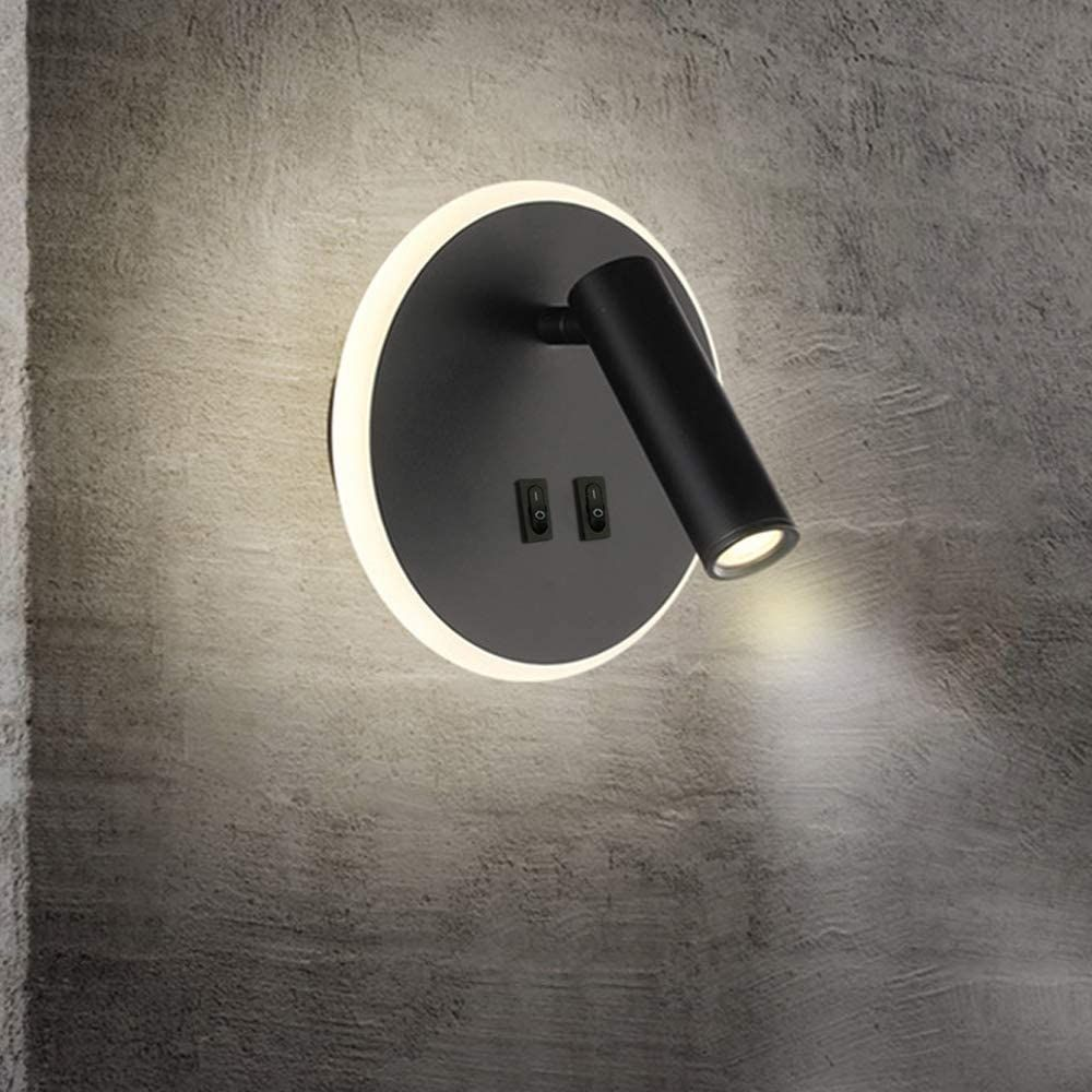 Eine moderne schwarze Wandleuchte mit rundem Sockel und verstellbarem zylindrischen Licht. Montiert an einer strukturierten grauen Wand.