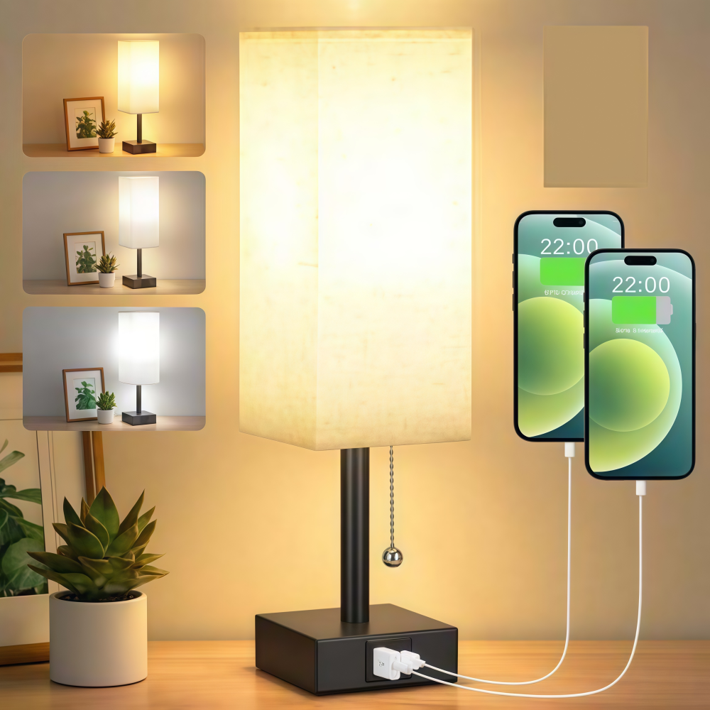 Eine beleuchtete Lampe mit ladenden Telefonen. Die Lampe hat einen quadratischen Schirm und einen schwarzen Sockel. Zwei Telefone werden geladen. Es gibt einige gerahmte Fotos.