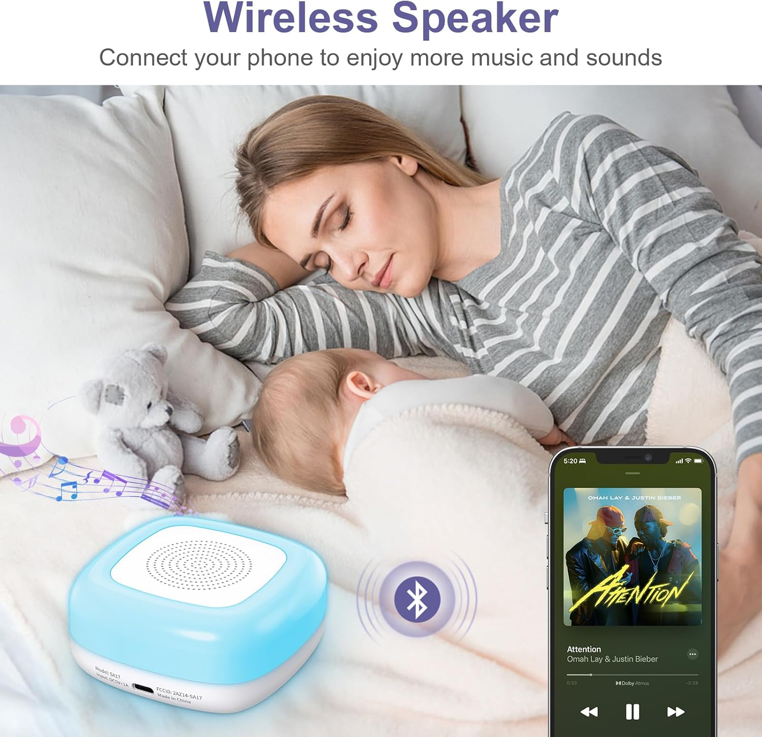 Eine Frau und ein Baby schlafen im Bett. Ein Bluetooth-Lautsprecher befindet sich in der Nähe des Babys. Ein Telefon zeigt Musik an.