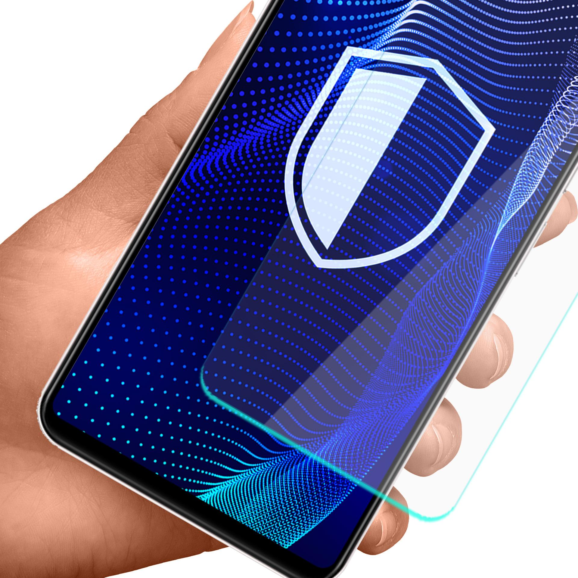 Dłoń trzymająca smartfon z ikoną tarczy na ekranie. Niebieskie tło z wzorem fal. Widoczna osłona ekranu.