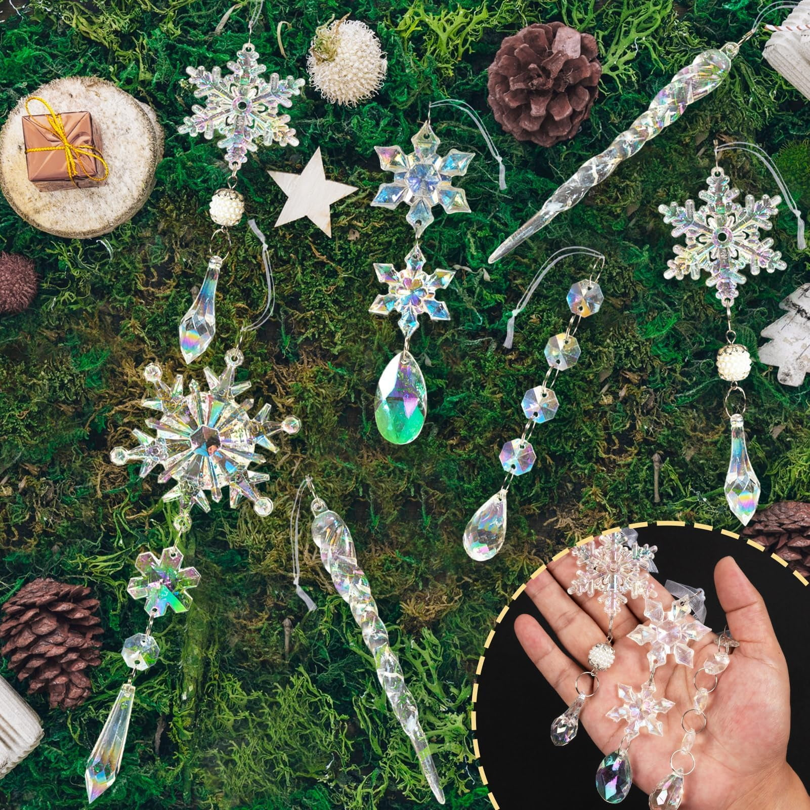 Nahaufnahme auf grünem Moosgrund. Kristallschneeflocken und Eiszapfen sind angeordnet, zusammen mit einem Geschenk, Tannenzapfen und Stern.