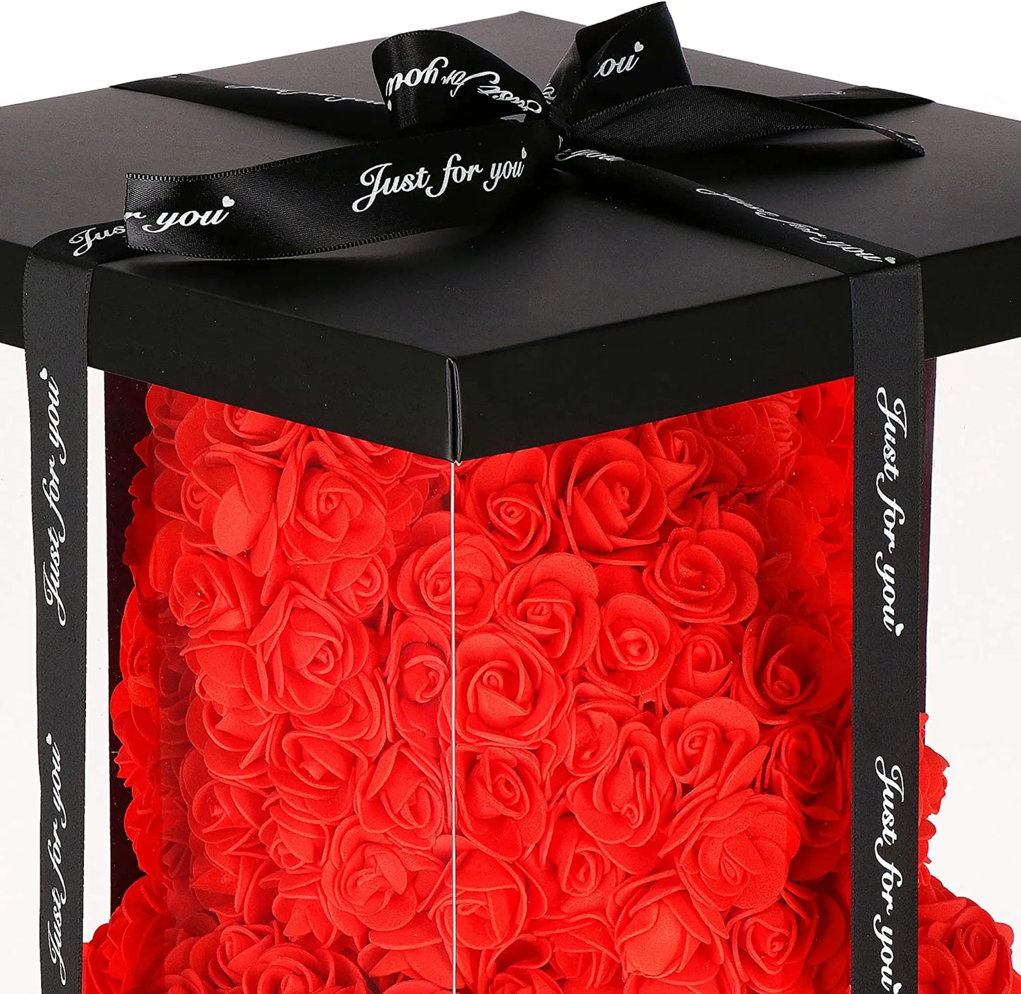 Ein roter Rosenbär in einer durchsichtigen Box mit einem schwarzen Band mit der Aufschrift 'Nur für dich'.