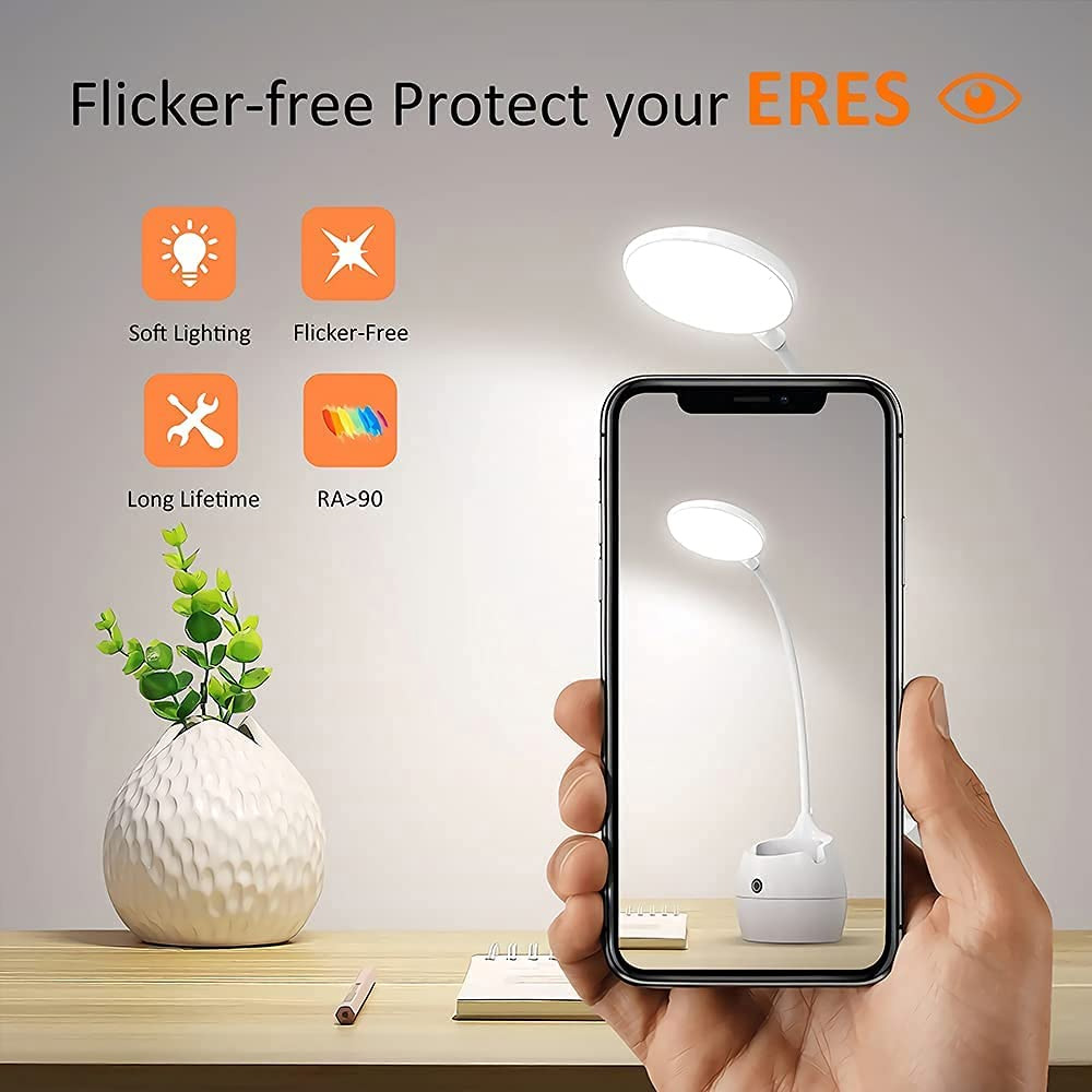 Eine Hand hält ein Telefon, das eine weiße Schreibtischlampe zeigt. Symbole heben weiche Beleuchtung, flimmerfrei, lange Lebensdauer und RA<gt/>90 hervor.