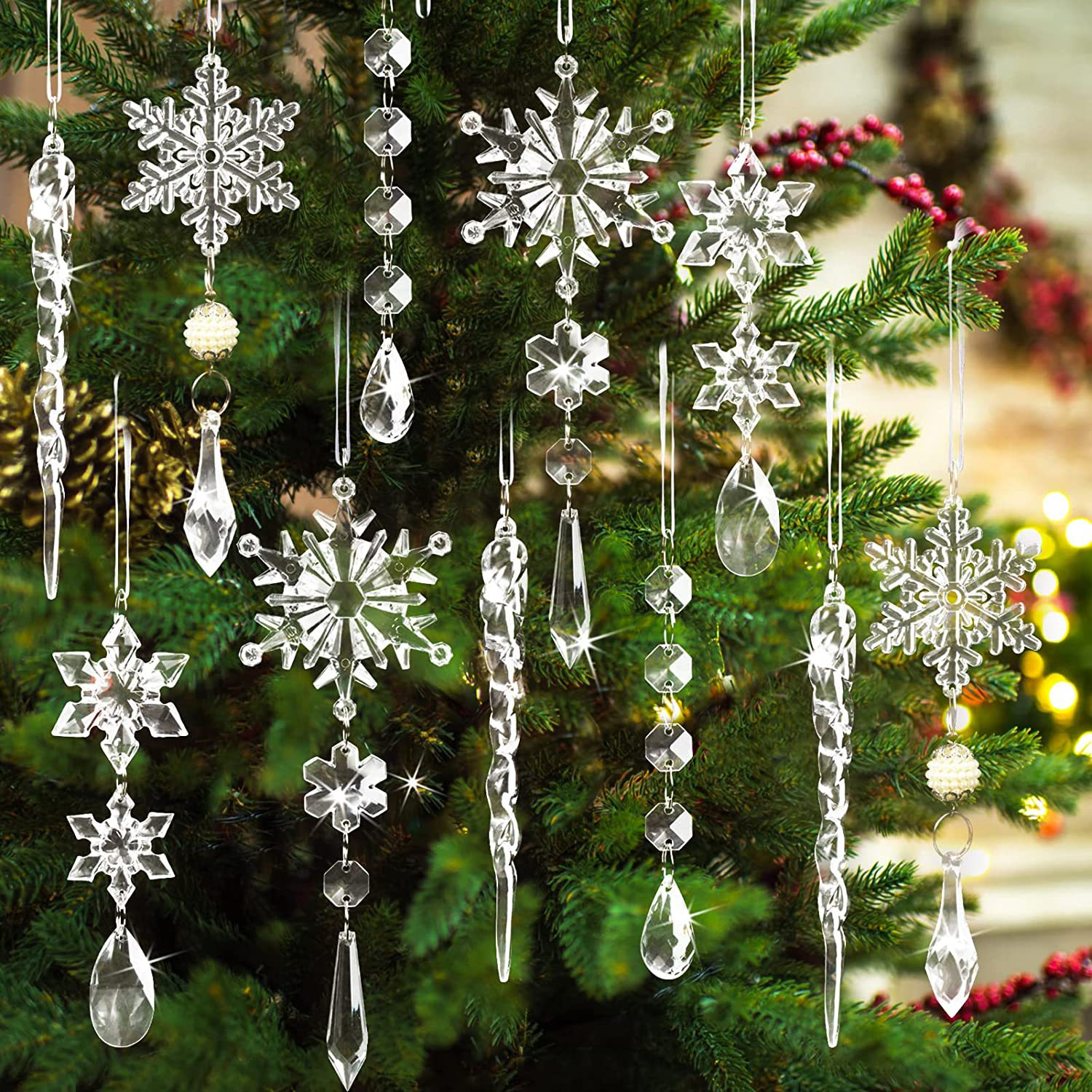 Transparente Kristallornamente, Schneeflocken und Eiszapfen hängen an einem grünen Weihnachtsbaum mit verschwommenen Lichtern im Hintergrund.