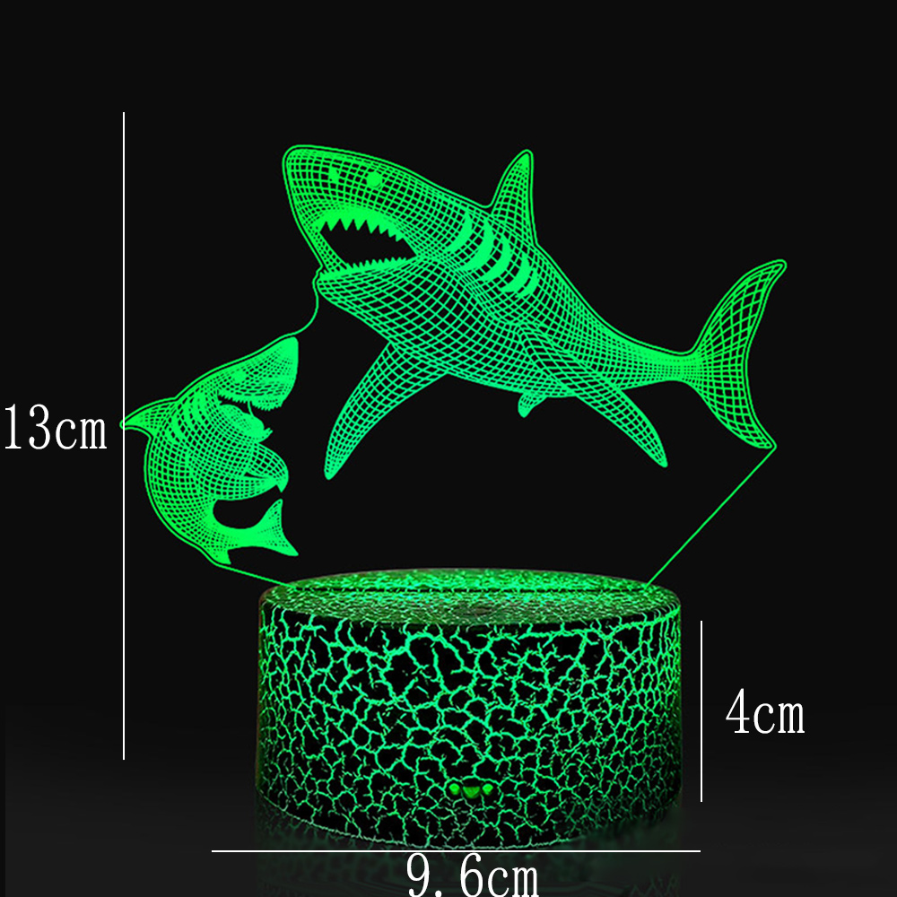 Eine grüne Haifisch-Lampe. Sie zeigt zwei Haie und einen rissigen Sockel. Die Abmessungen sind 13 cm hoch, 9,6 cm breit und die Basis ist 4 cm.