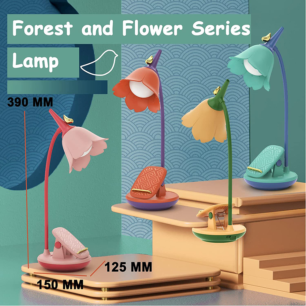 Vier blütenförmige Lampen in verschiedenen Farben stehen auf einer Holzoberfläche. Die Lampen haben einen Clipfuß und einen flexiblen Hals.
