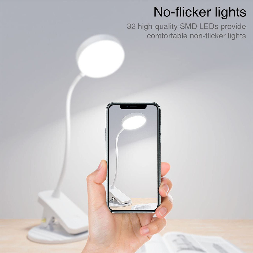 Eine Hand, die ein Telefon hält, das eine weiße Schreibtischlampe zeigt. Die Lampe steht auf einem Schreibtisch. Der Text lautet: Keine flackernden Lichter.