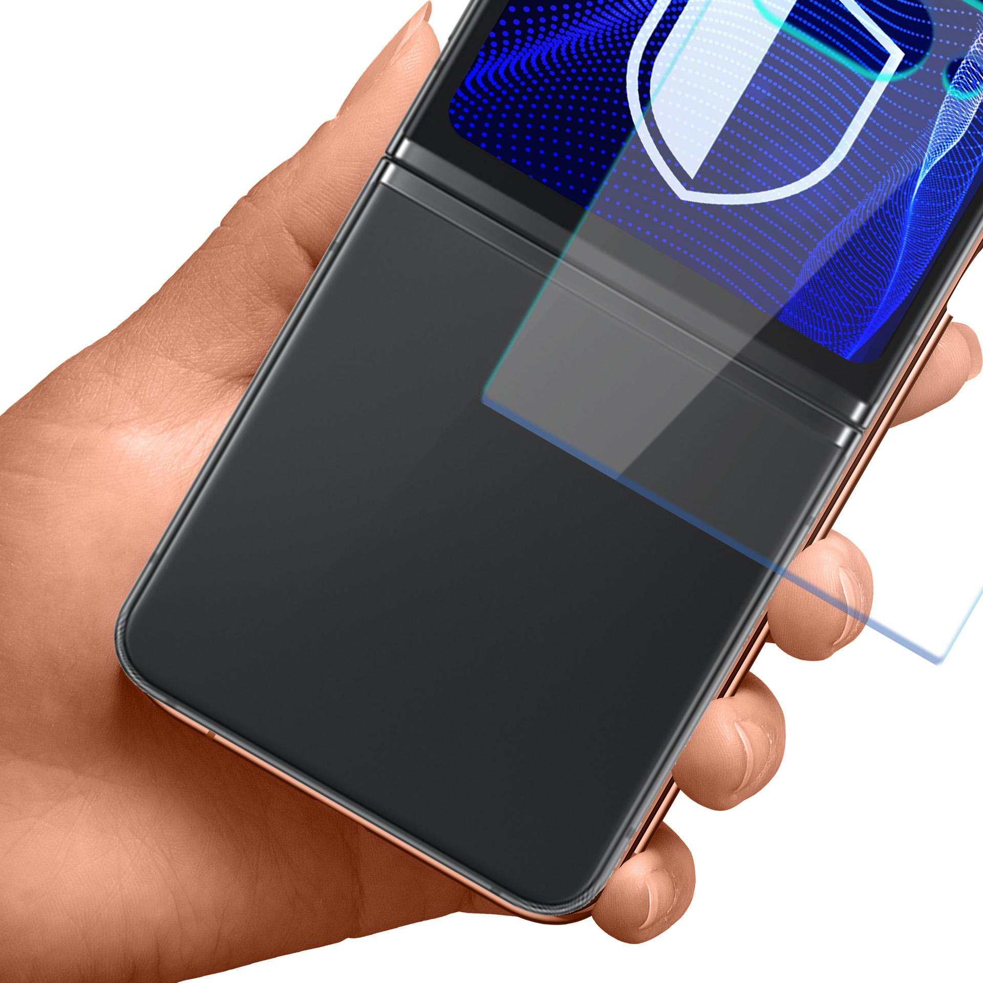 Ręka trzyma częściowo otwarty, czarny składany telefon z niebieską grafiką na ekranie.