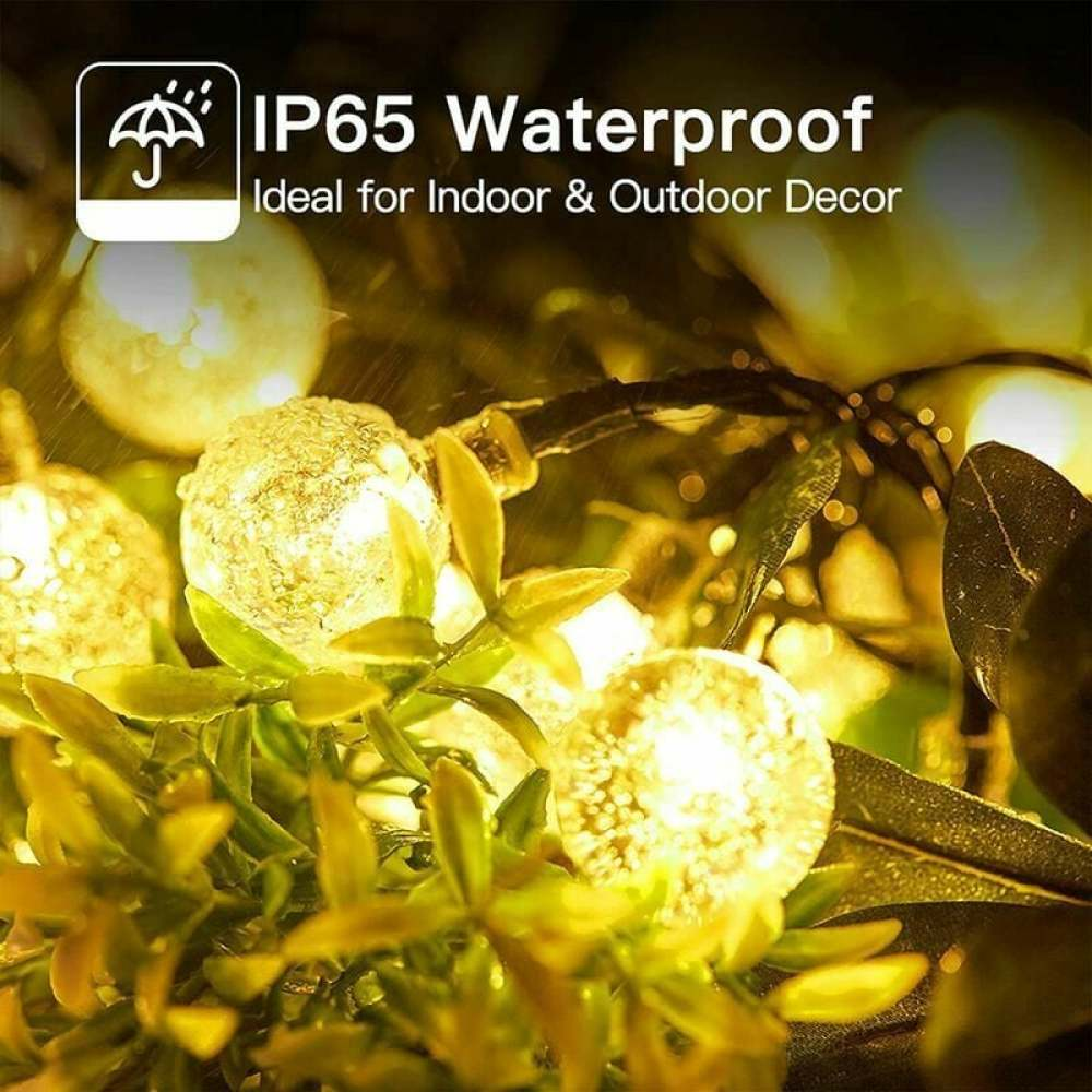Nahaufnahme von Lichterketten mit runden Glühbirnen, grünen Blättern und Text 'IP65 Wasserdicht'.