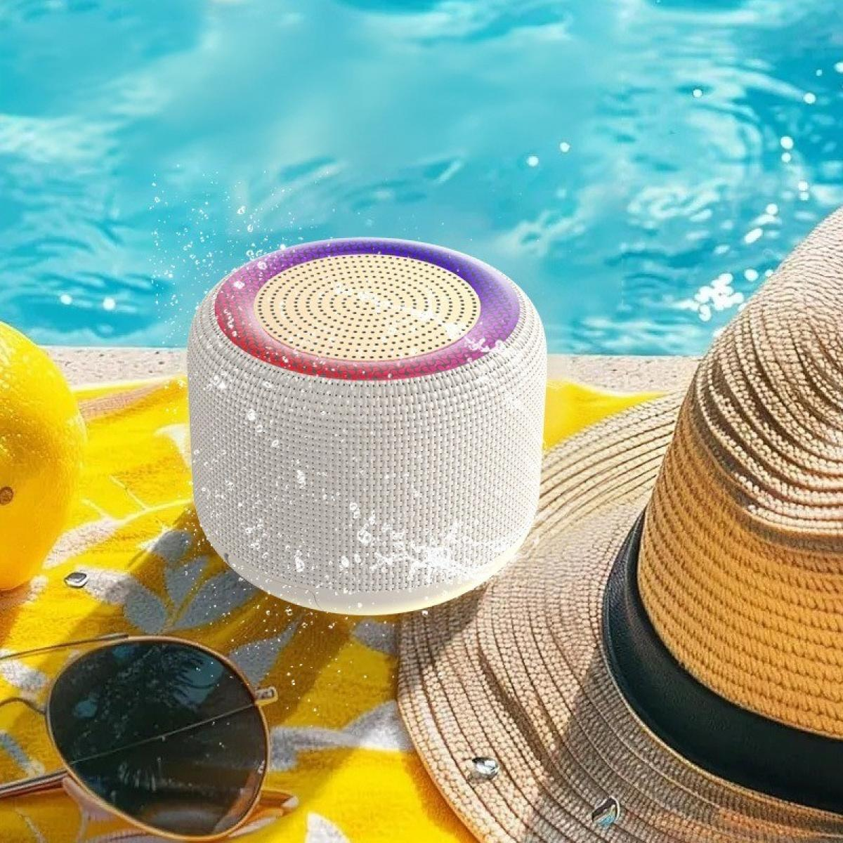 Ein weißer Lautsprecher mit lila Oberseite steht in der Nähe eines Pools. Ein Strohhut, eine Zitrone und eine Sonnenbrille liegen auf einem gelben Handtuch.