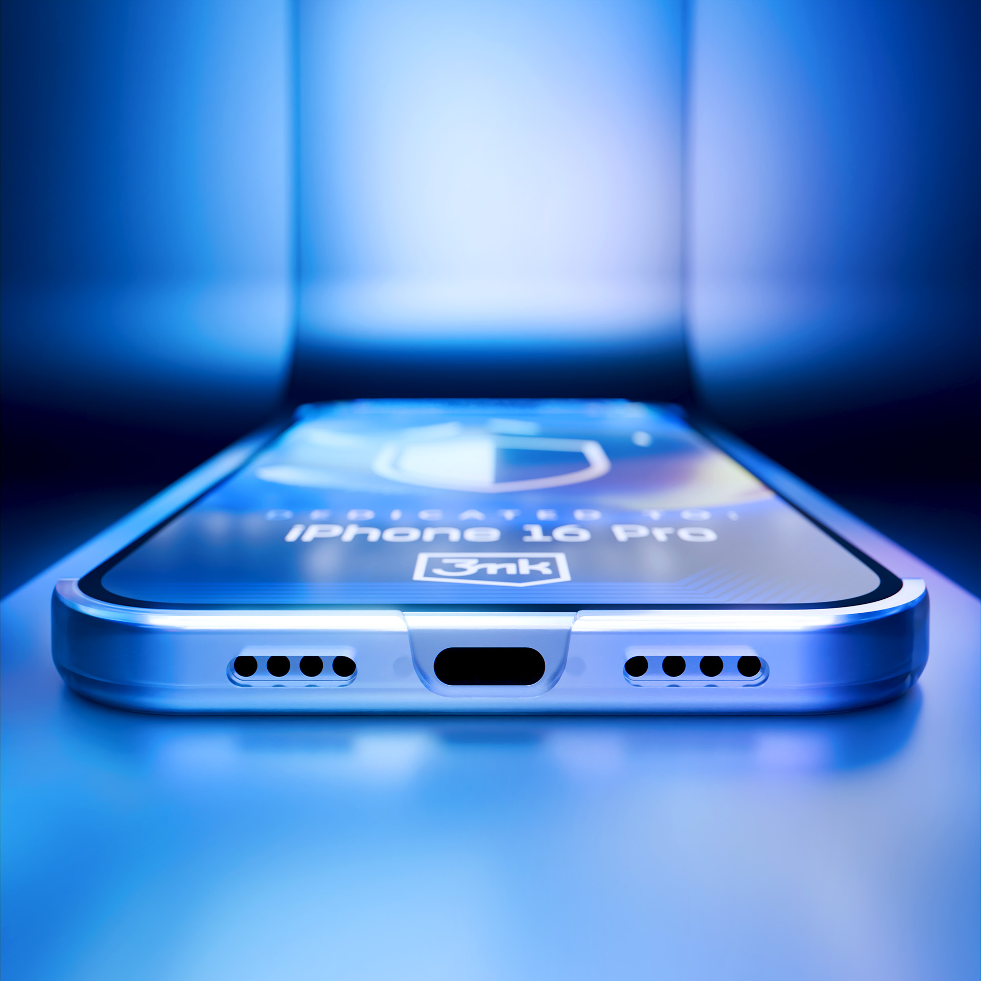 Zbliżenie iPhone'a 16 Pro z ochraniaczem ekranu. Scena oświetlona niebieskim światłem, tworząc futurystyczny efekt.
