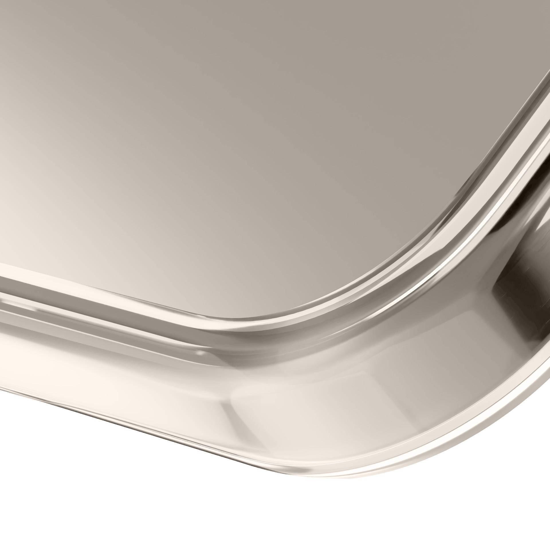 Primo piano di un oggetto metallico lucido e curvo con una superficie liscia. Il colore è una tonalità chiara e neutra su sfondo bianco.
