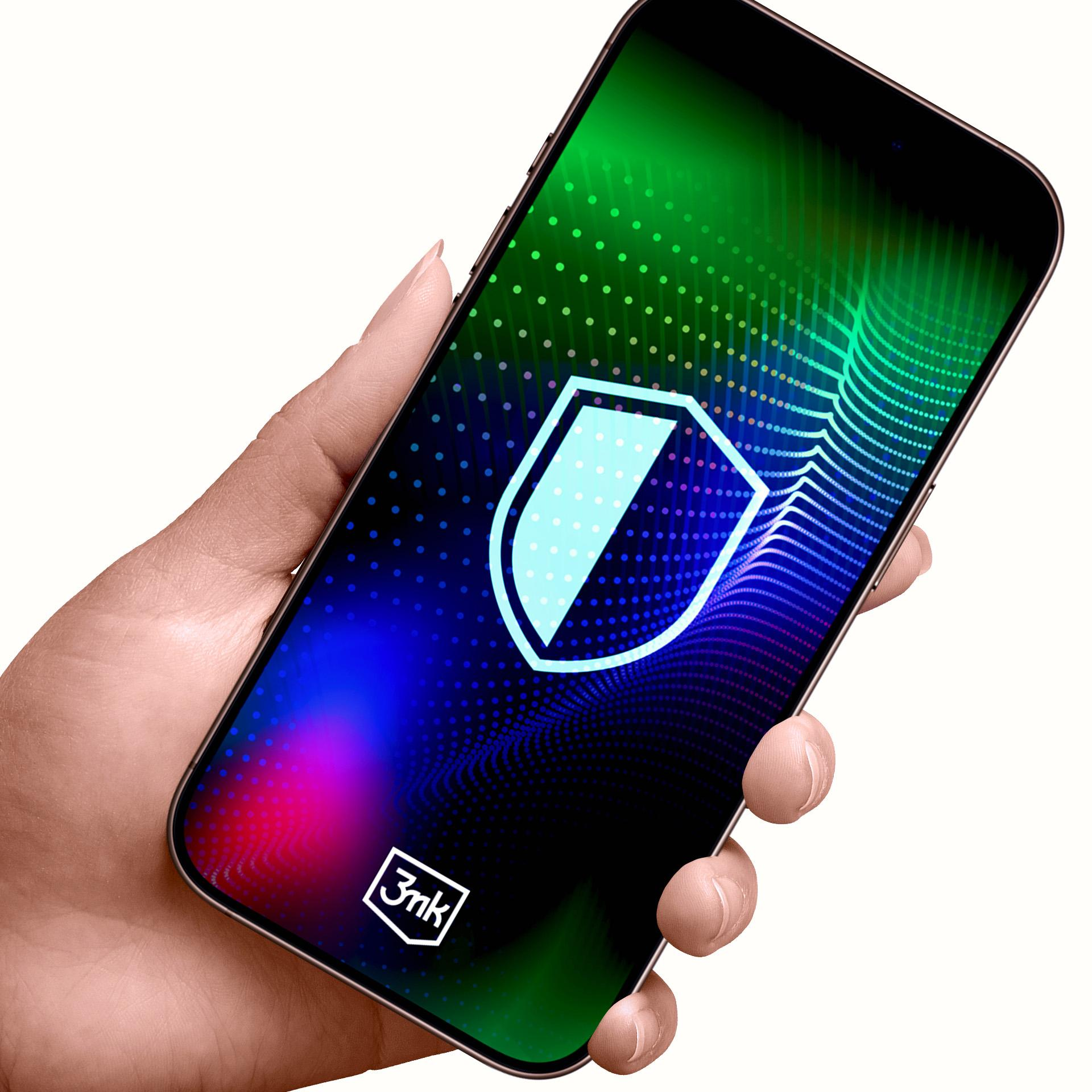 Dłoń trzyma smartfon. Ekran z tarczą. Tło: zielony, niebieski i fioletowy gradient.