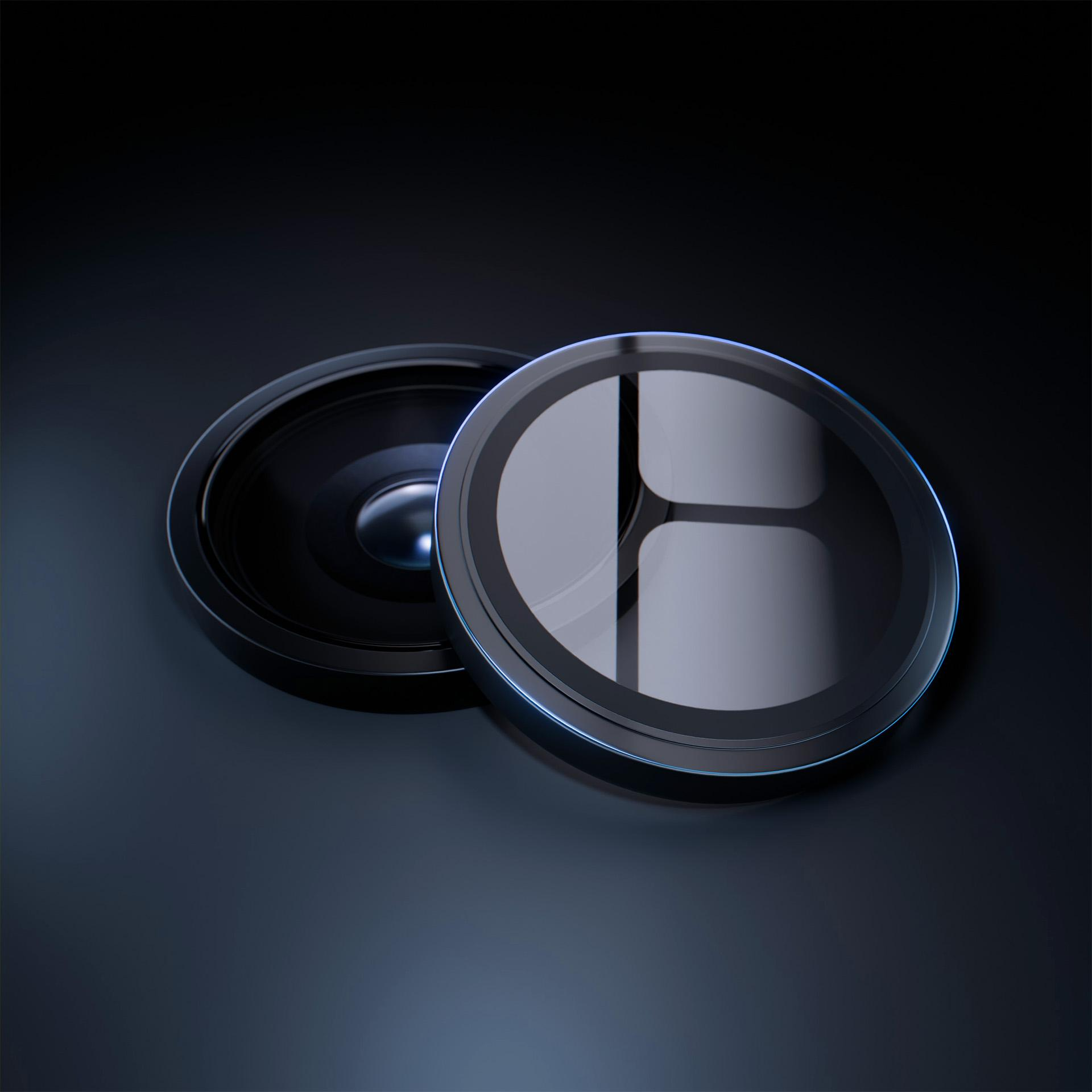 Dwa czarne obiektywy na ciemnej powierzchni. Jeden jest otwarty, drugi zamknięty.