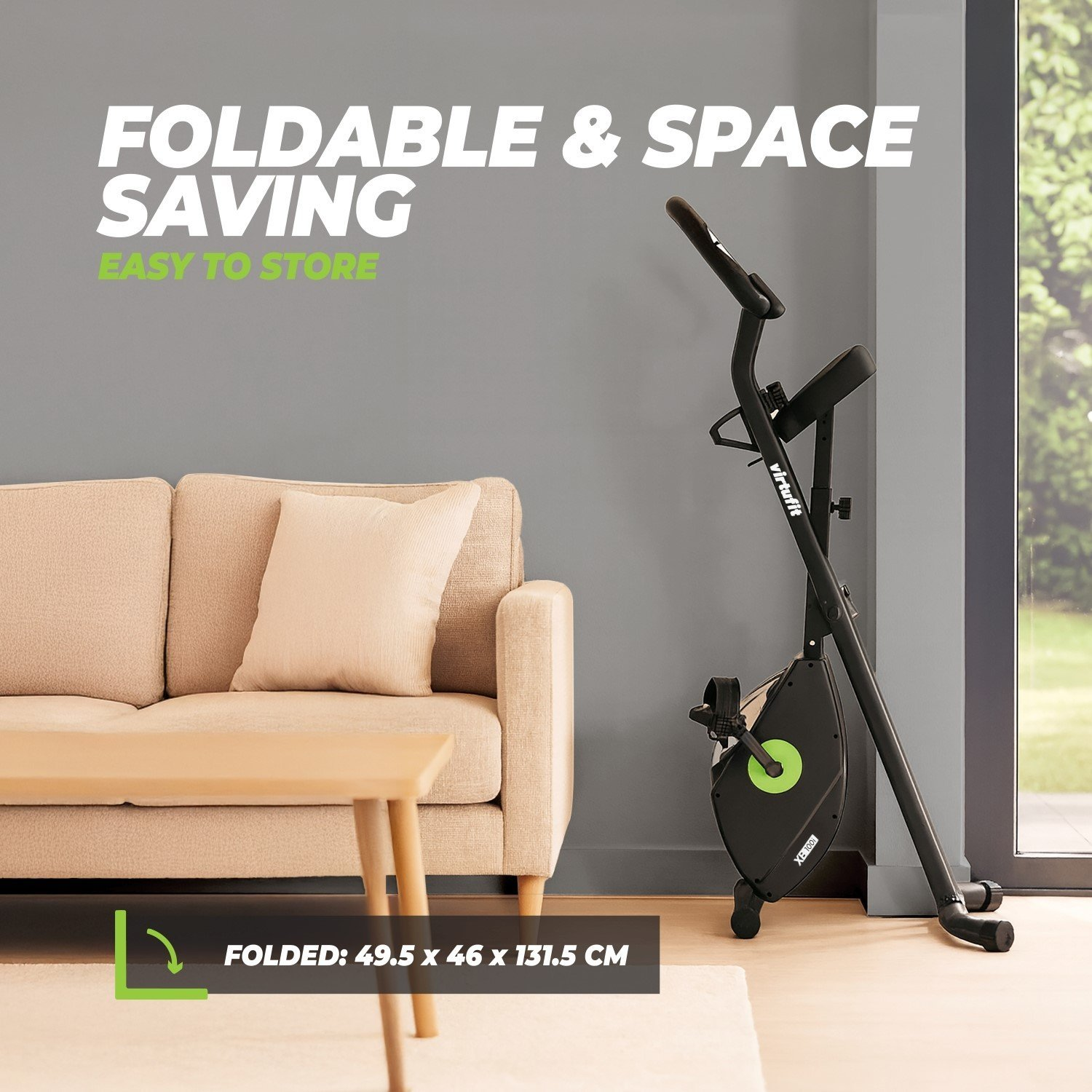 Ein Heimtrainer lehnt an einer grauen Wand. Davor stehen eine beige Couch und ein Tisch. Der Text sagt 'Foldable & Space Saving'.