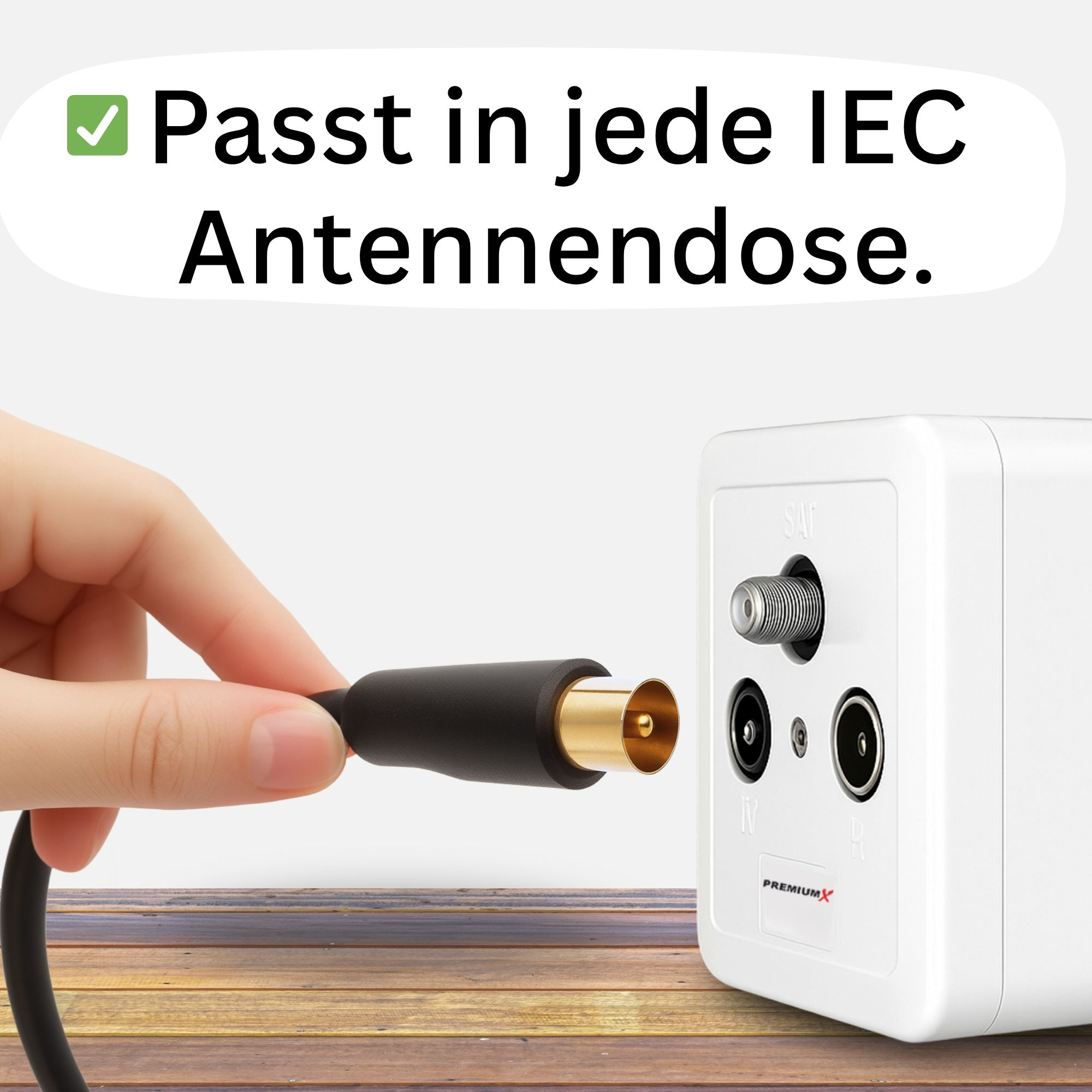 Hand steckt ein schwarzes Koaxialkabel in eine weiße Box mit SAT- und TV-Anschlüssen.