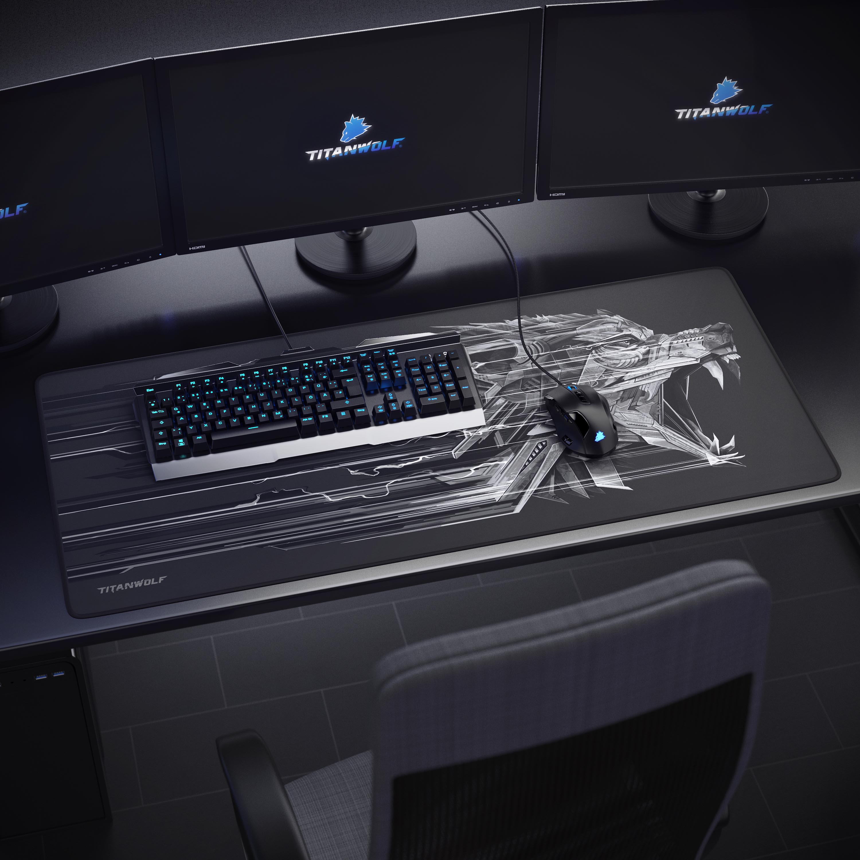 Ein Gaming-Setup mit drei Monitoren, Tastatur, Maus und einem Titanwolf-Mauspad. Ein Stuhl steht hinter dem Schreibtisch.