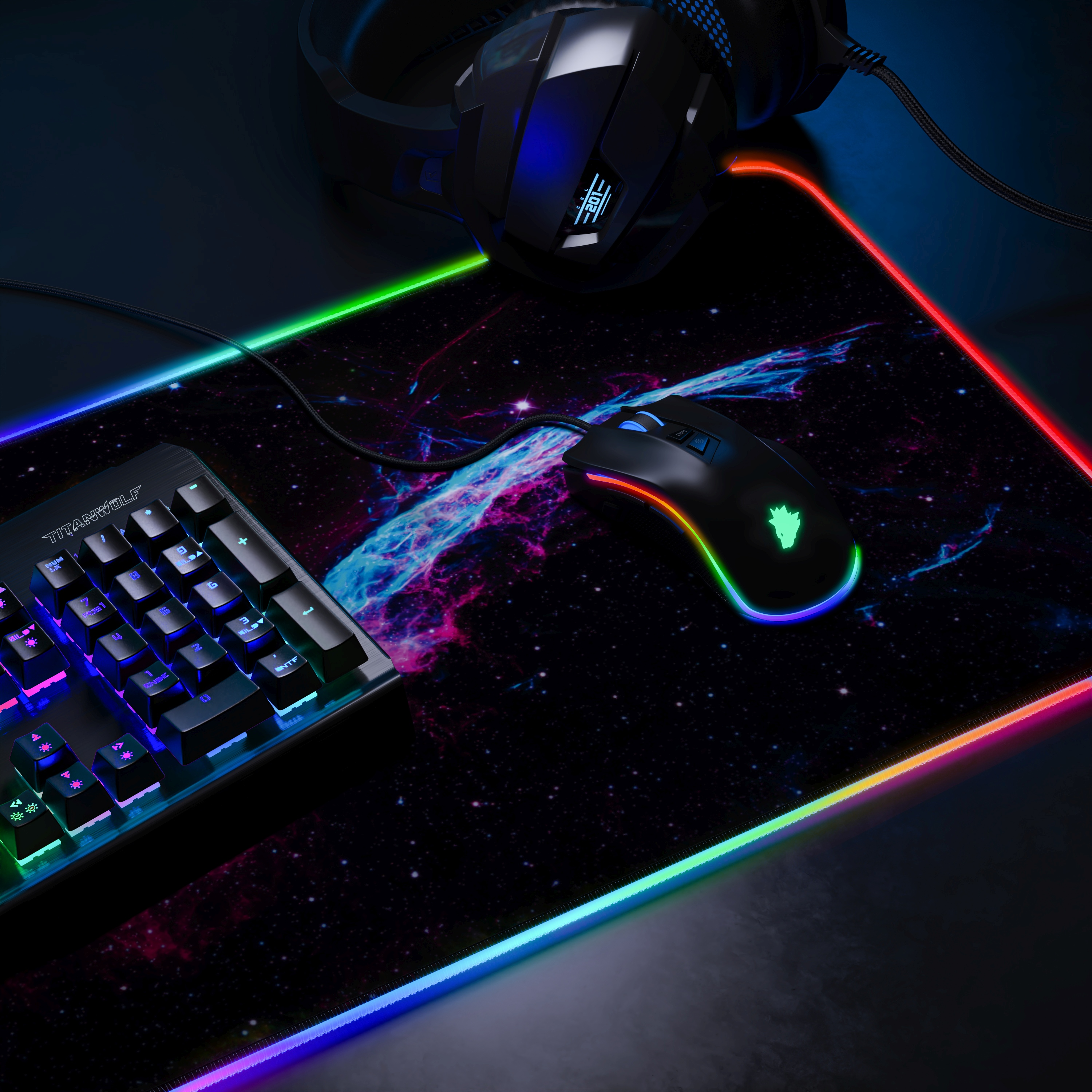 Gaming-Setup mit Tastatur, Maus, Kopfhörern und einem Mauspad mit Galaxy-Design und RGB-Beleuchtung.