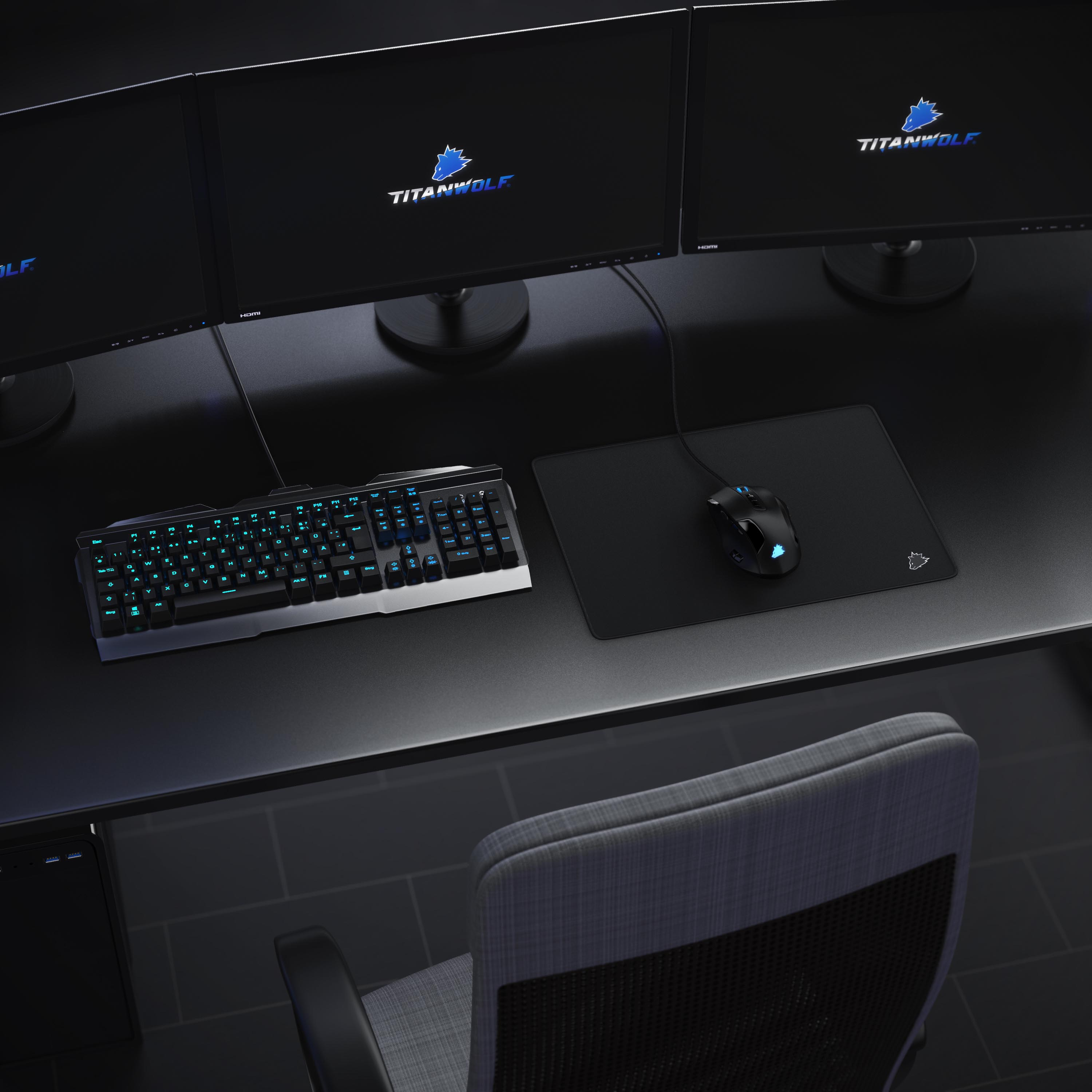 Ein Gaming-Setup mit drei Monitoren, Tastatur, Maus und Stuhl. Monitore zeigen das Titanwolf-Logo.
