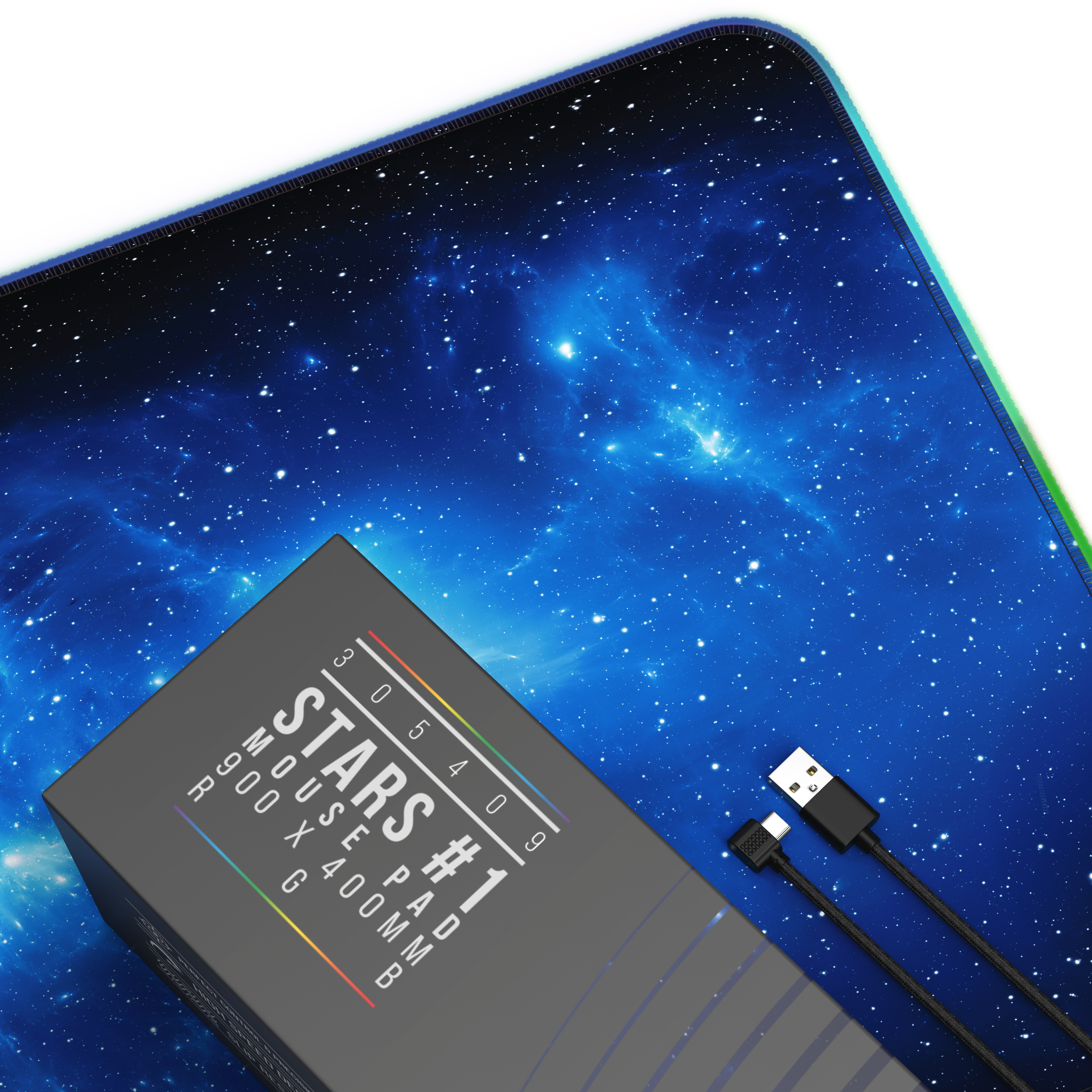 Ein Mauspad mit Sternenhimmel-Design und eine Box mit Text. Zwei schwarze USB-Kabel sind ebenfalls sichtbar.