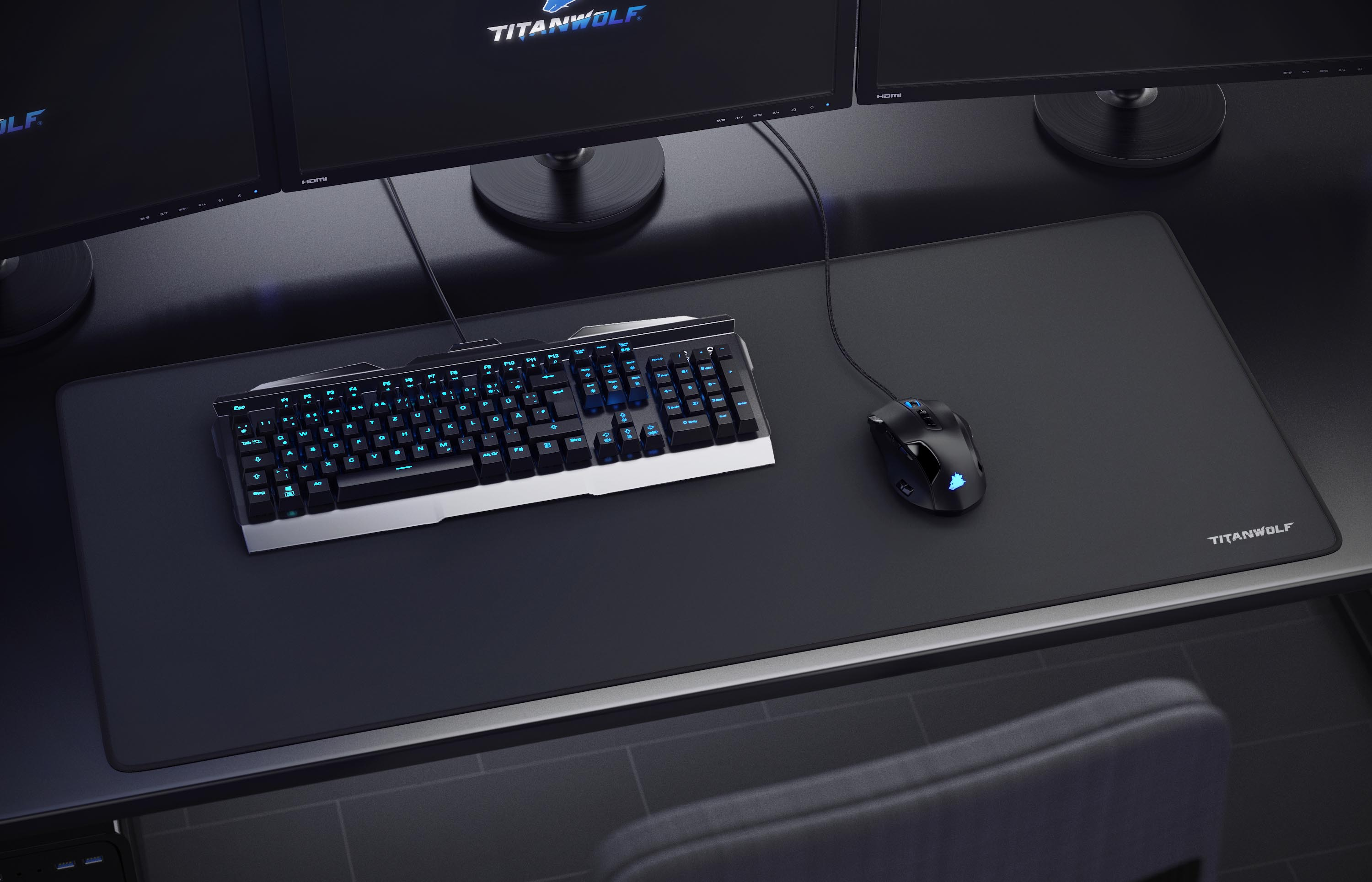 Schreibtisch-Setup mit Tastatur, Maus, Mauspad und Monitoren. Tastaturtasten leuchten blau. Titanwolf-Logo sichtbar.