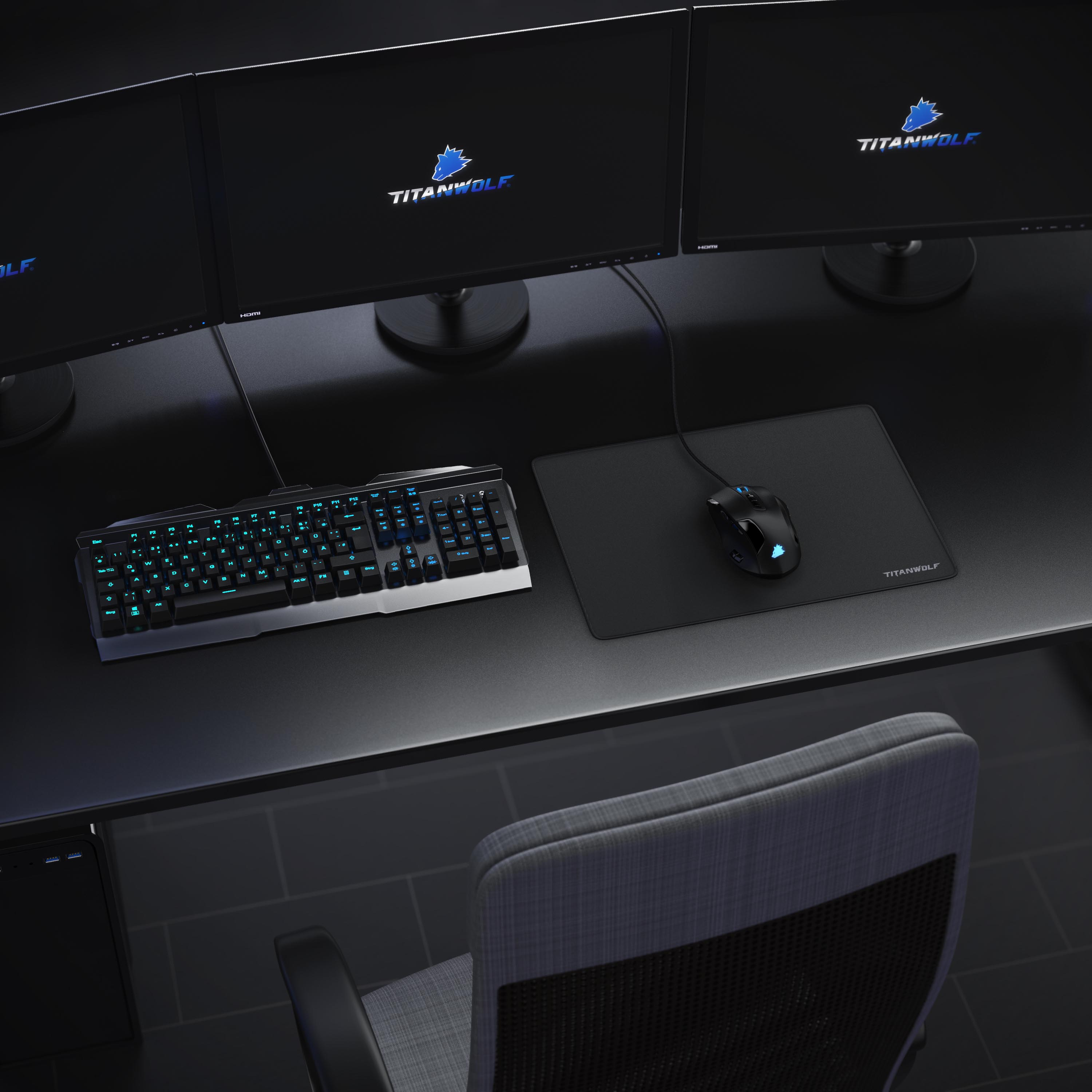 Ein Gaming-Setup mit drei Monitoren, Tastatur, Maus und Stuhl. Die Monitore zeigen das TITANWOLF-Logo.