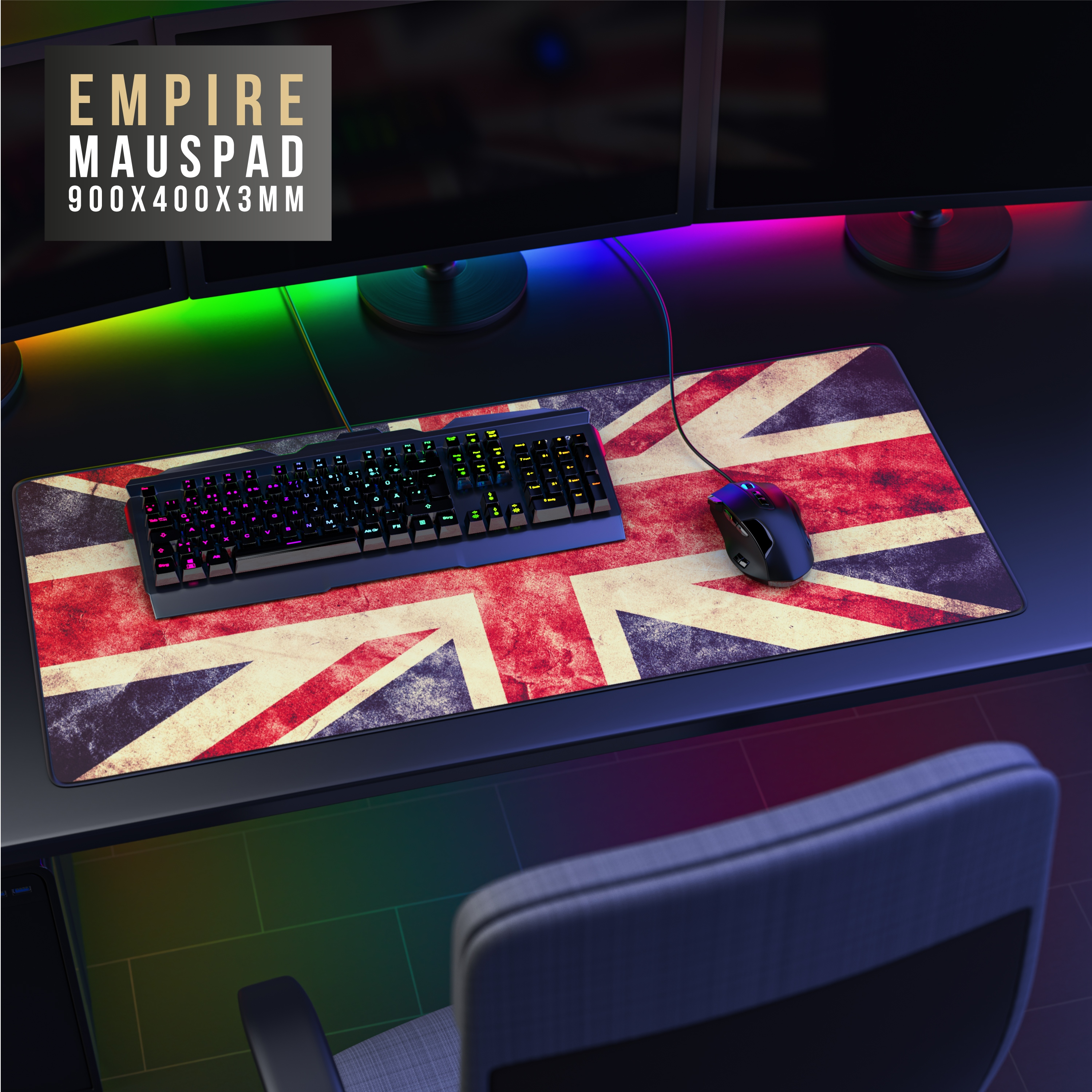 Ein Schreibtisch-Setup mit einem Union-Jack-Mauspad, einer Tastatur und einer Maus. Im Hintergrund sind zwei Monitore zu sehen.