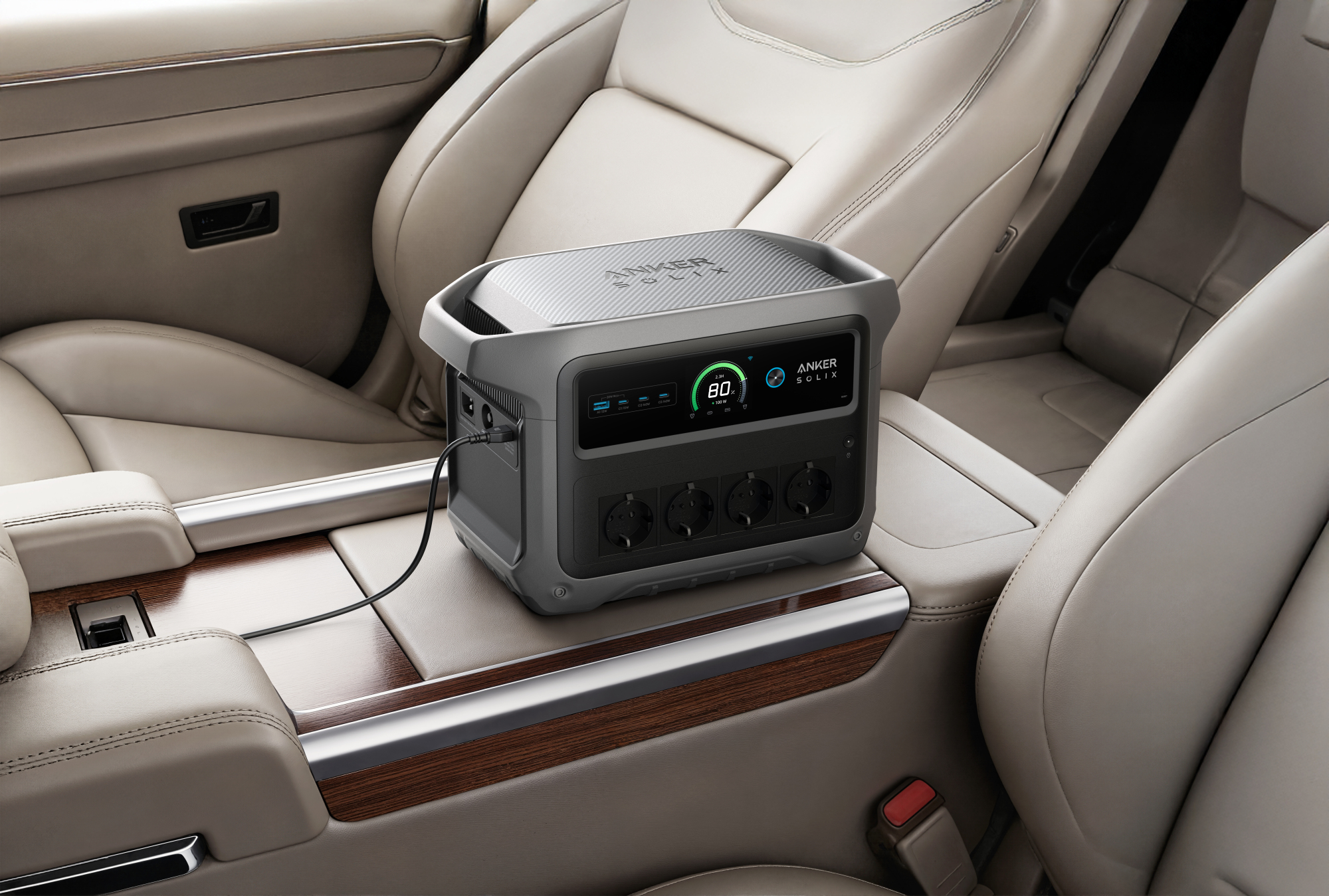 Anker Solix Powerstation im Auto. Auf einer Holzkonsolen. Beige Ledersitze umgeben es.