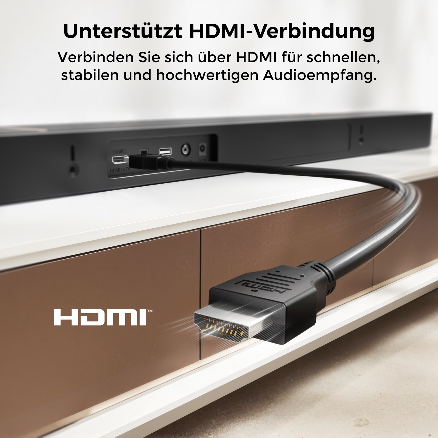 Ein schwarzes HDMI-Kabel, das in eine Soundbar an einem weißen und braunen Schrank eingesteckt ist. Text lautet 'HDMI'. Die Soundbar hat Anschlüsse.