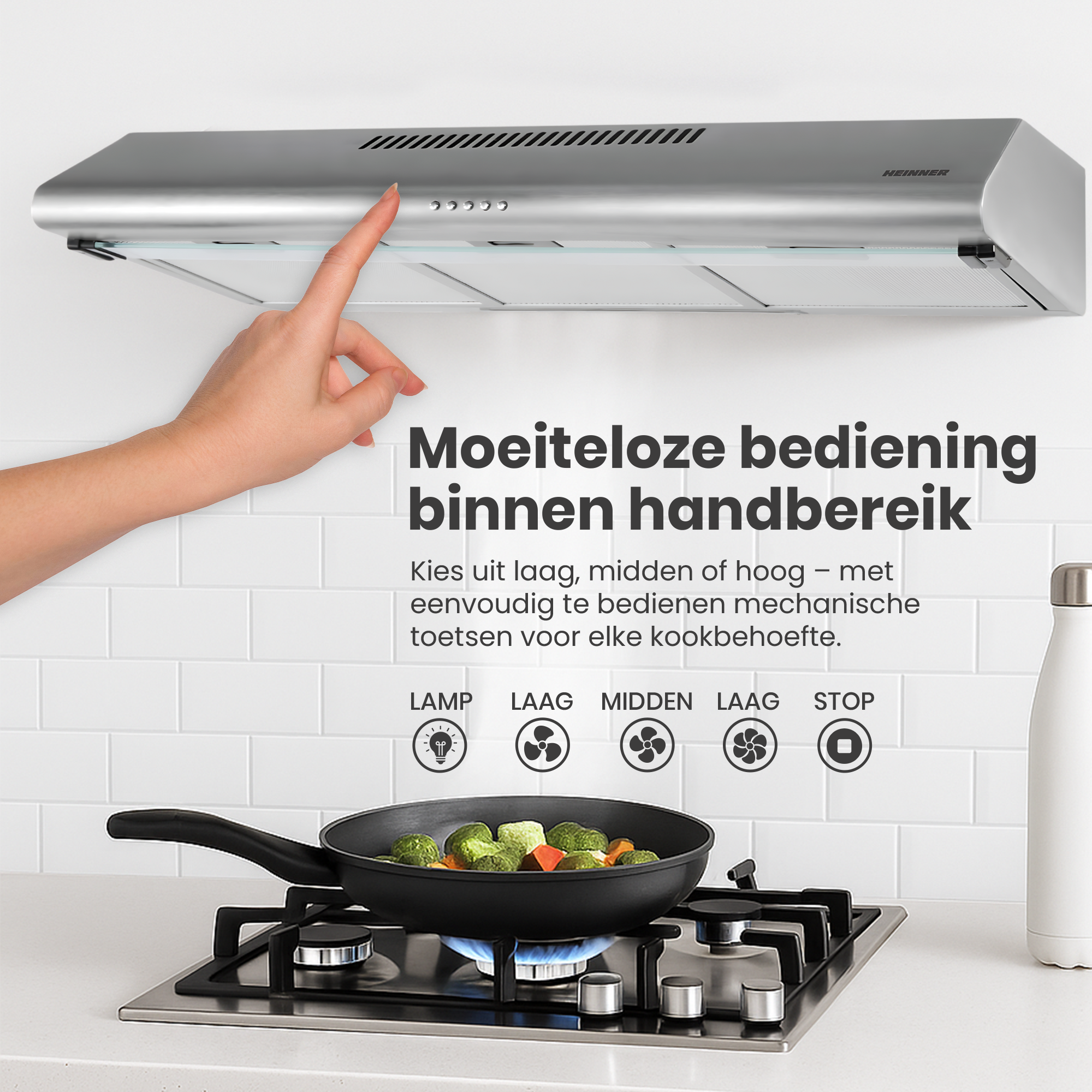 Een hand raakt een zilveren afzuigkap aan boven een fornuis met een pan groenten. Bedieningselementen staan onder.