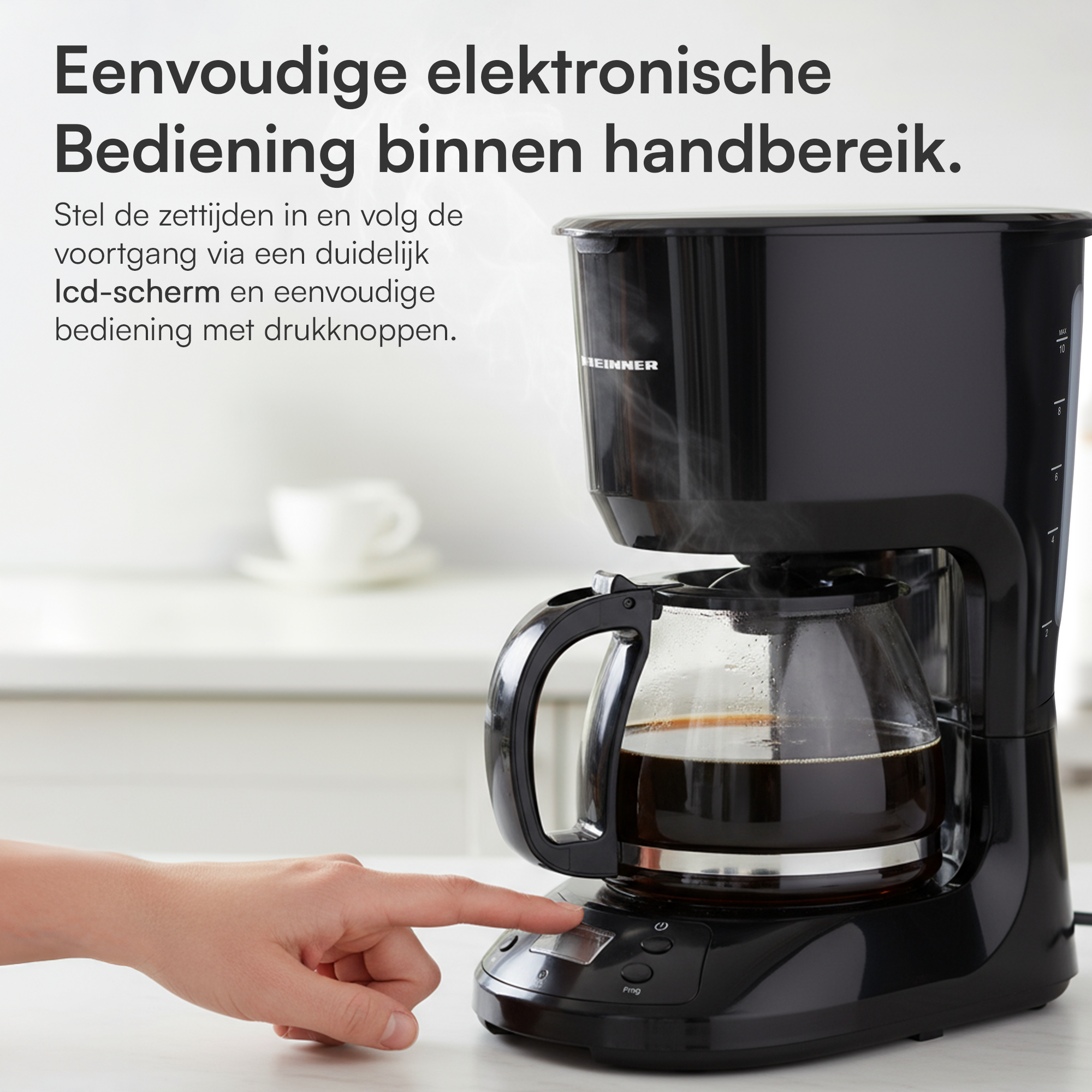 Eine schwarze Kaffeemaschine mit einer Hand, die eine Taste drückt. Dampf steigt aus der Kaffeekanne auf. Der Hintergrund hat eine Tasse und eine verschwommene Küche.