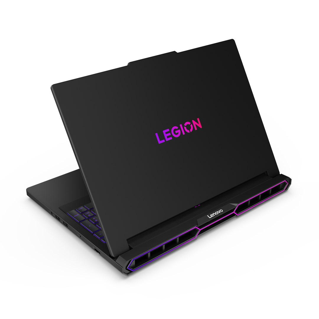 Czarny laptop Lenovo Legion, otwarty, z podświetlonym logo Legion. Fioletowe podświetlenie akcentuje klawiaturę i wyloty powietrza. Białe tło.