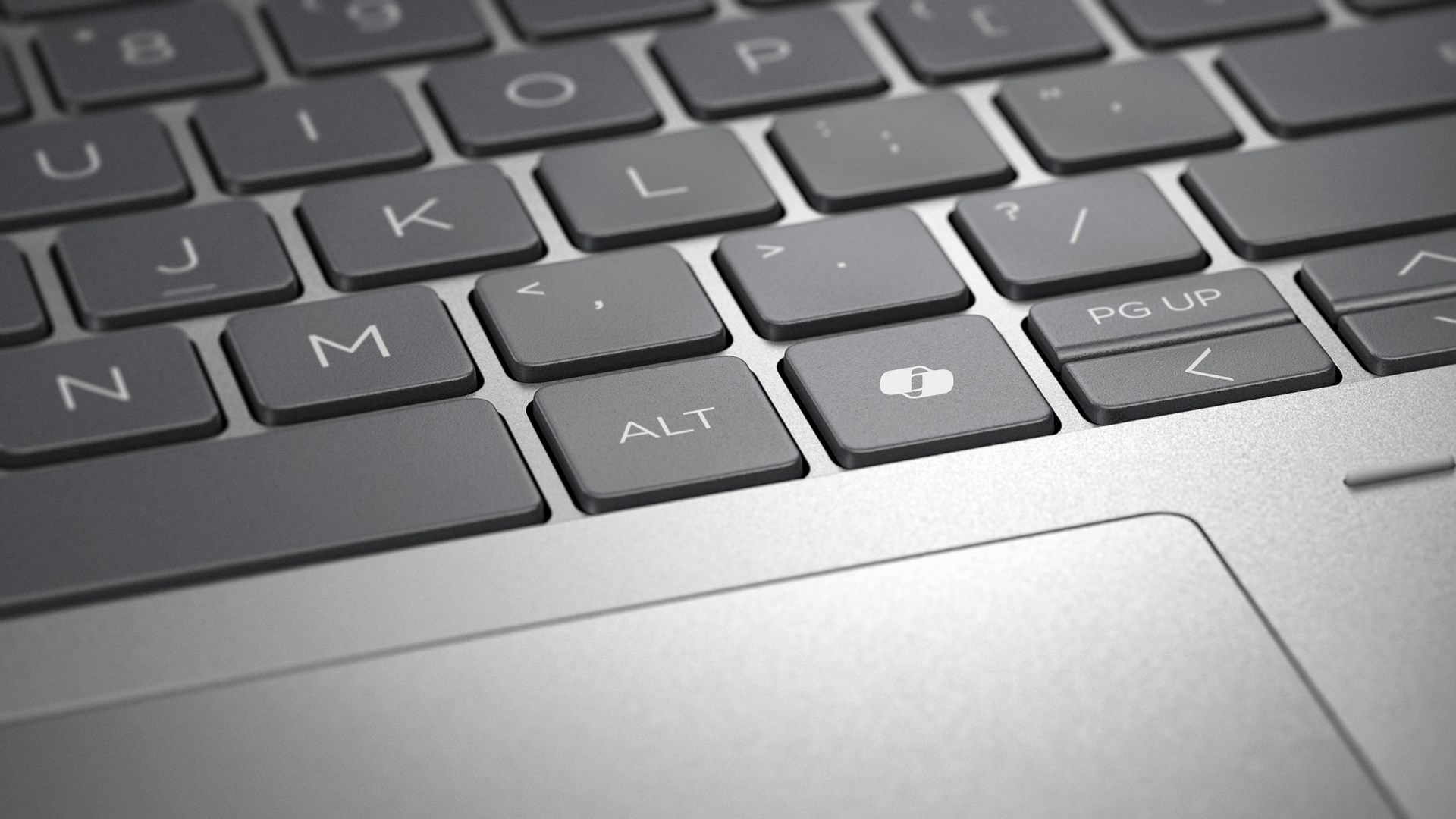 Zbliżenie klawiatury laptopa. Klawisze są szare z białymi literami i symbolami. Klawisz ALT jest widoczny, wraz z innymi.