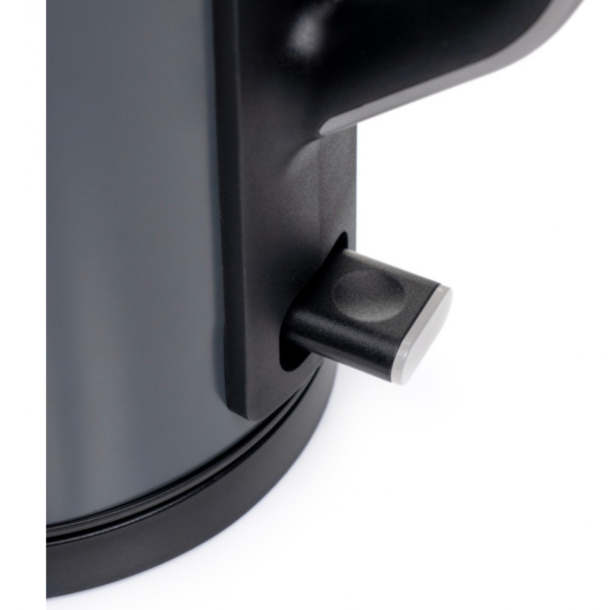 Zbliżenie czarnego czajnika elektrycznego z szarym przełącznikiem. Przełącznik jest prostokątny i wystający, ze srebrną krawędzią.