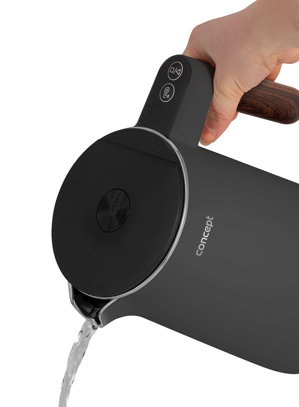 Ręka nalewa wodę z czarnego czajnika elektrycznego. Czajnik ma drewniany uchwyt i srebrne akcenty, z marką 'concept'.