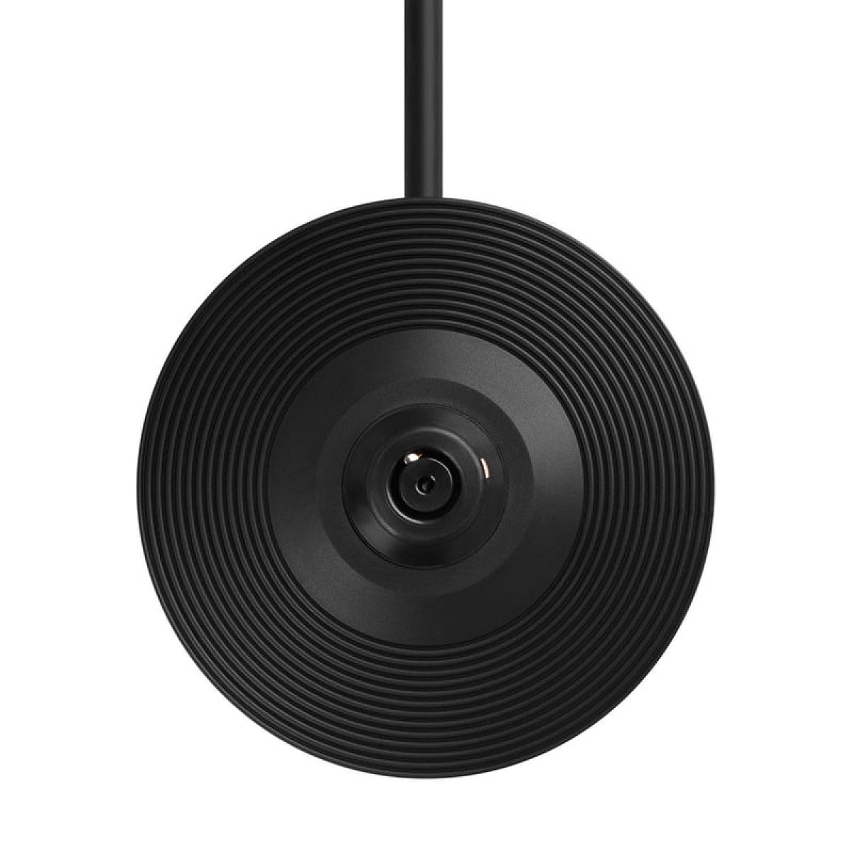 Zbliżenie czarnego, okrągłego obiektu ze współśrodkowymi grzbietami. Czarny przewód wychodzi z góry.