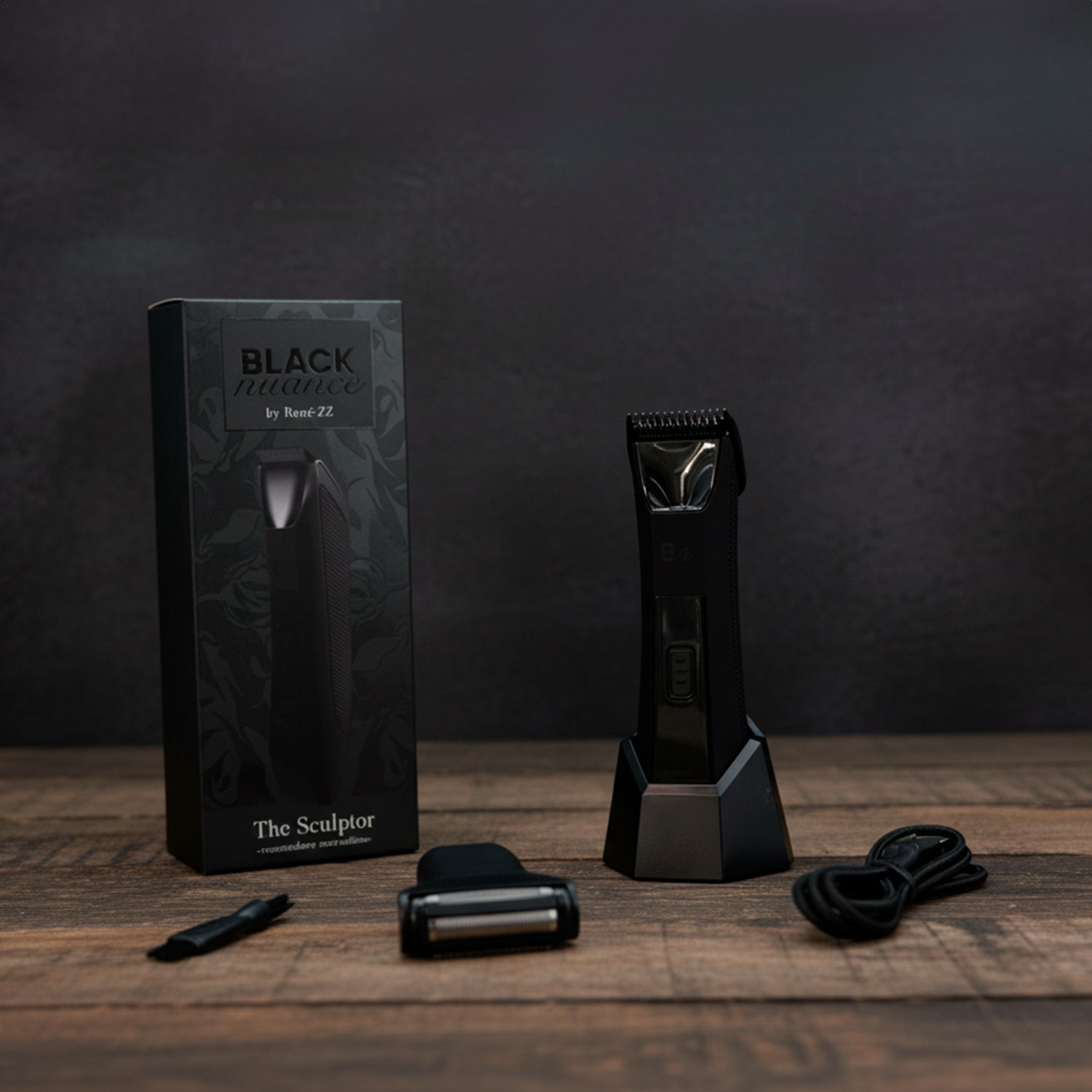 Kit de aseo negro sobre madera. Incluye recortadora, cuchillas, cepillo y cargador. La caja dice 'Black Nuance by René-ZZ'.