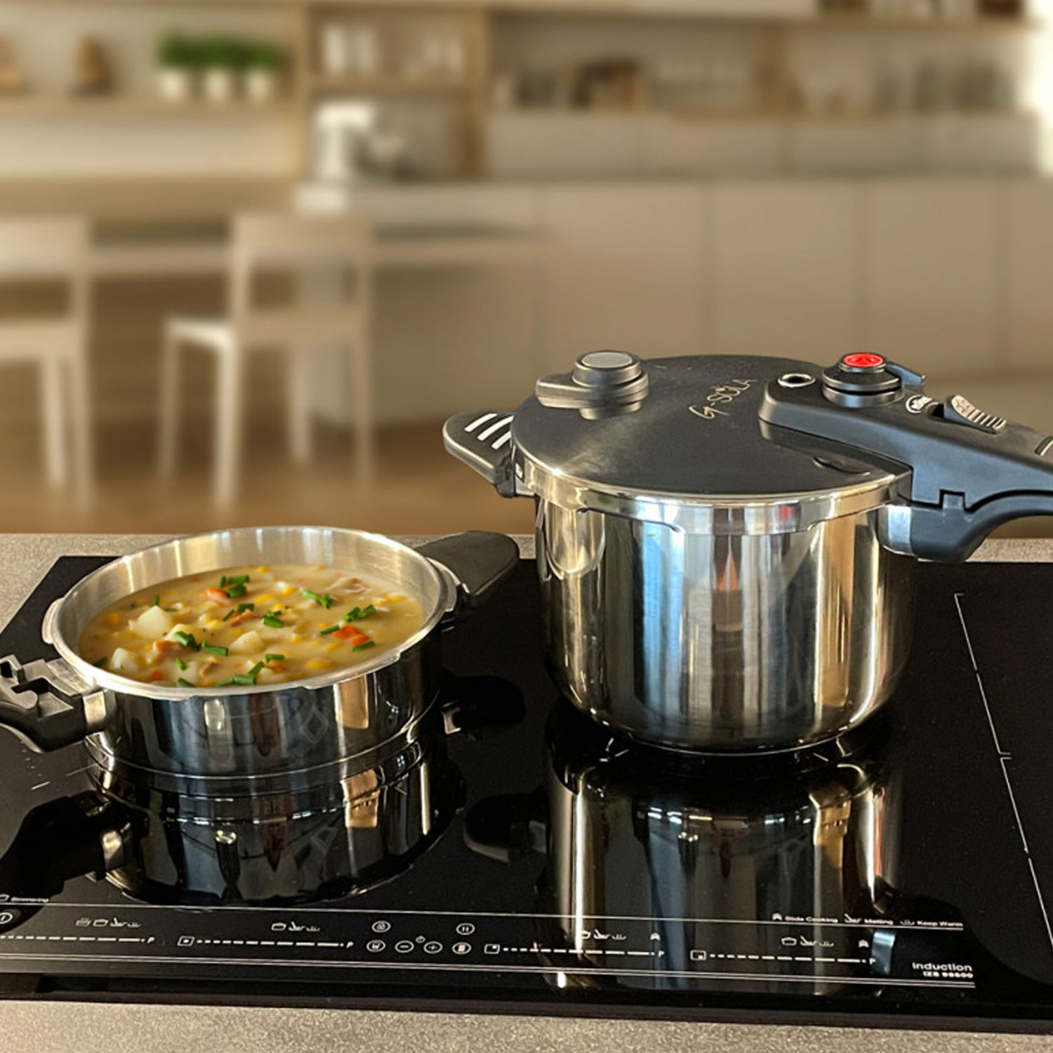 Dos ollas a presión de acero inoxidable en una placa de inducción negra. Una olla contiene sopa. Fondo de cocina.