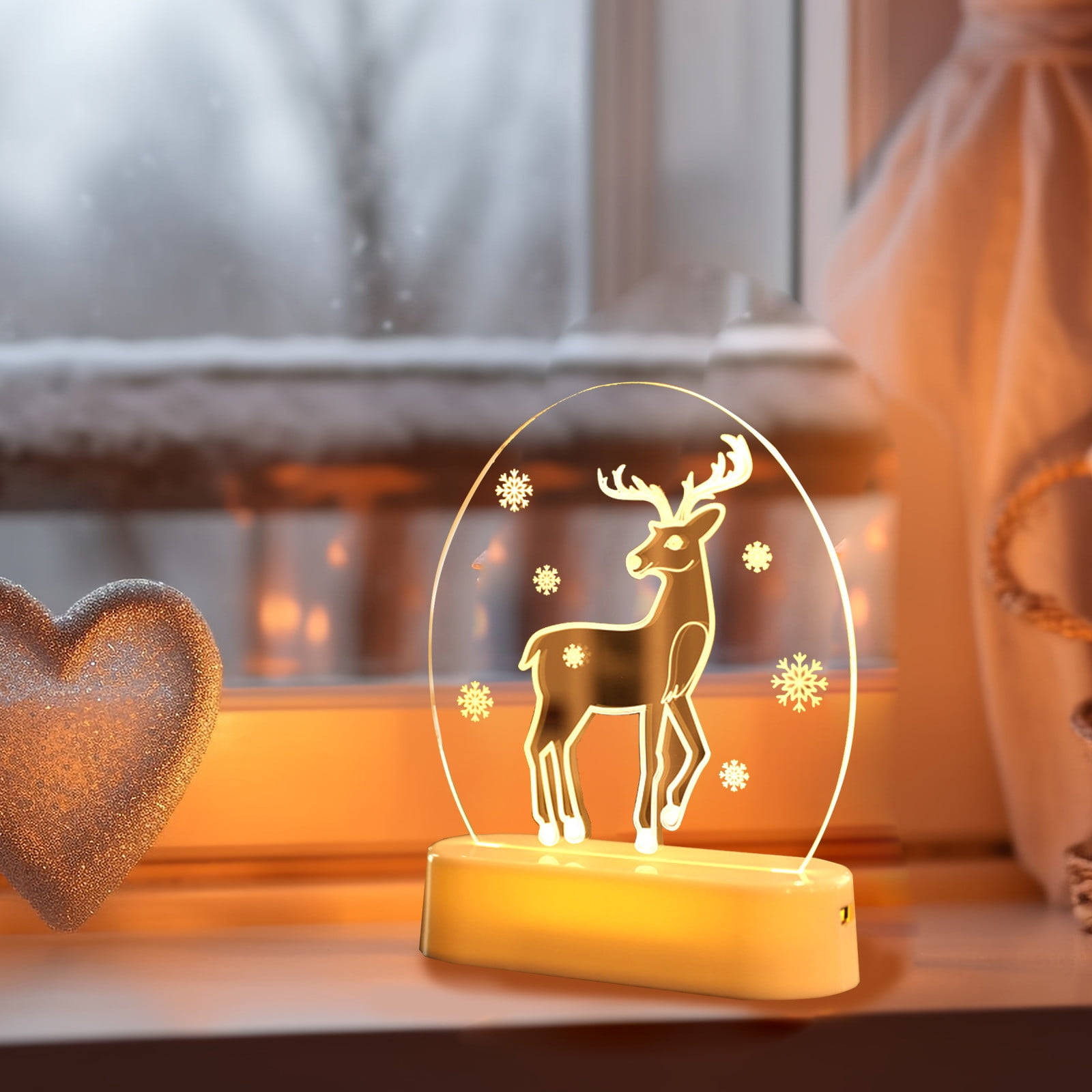Eine beleuchtete Hirschlampe auf einer Fensterbank, mit Herz und schneebedeckter Szene.