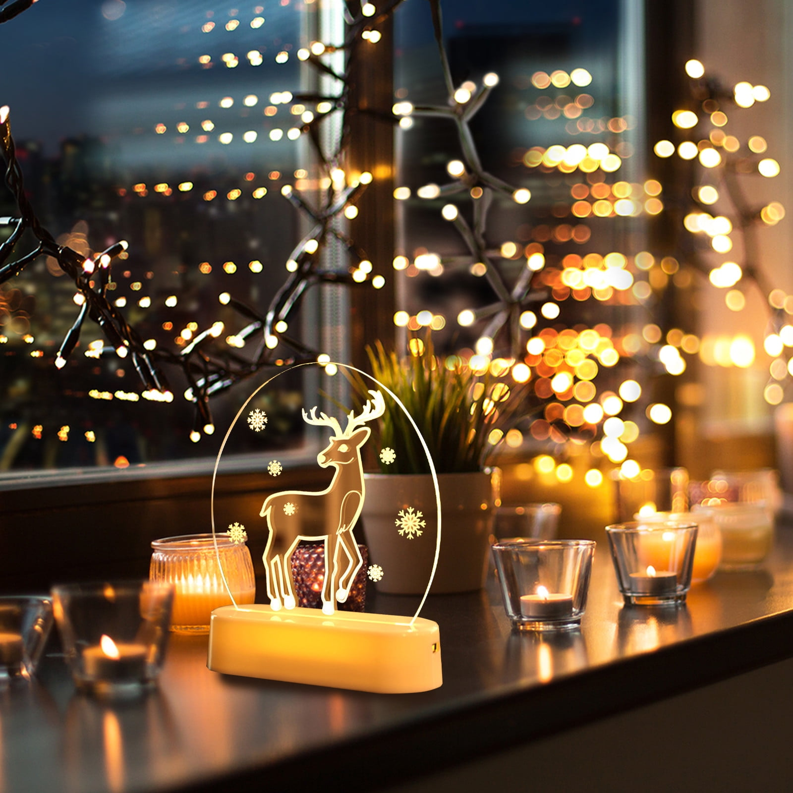 Eine beleuchtete hirschförmige Dekoration steht auf einem Tisch mit Kerzen und Lichterketten. Stadtlichter sind durch ein Fenster sichtbar.