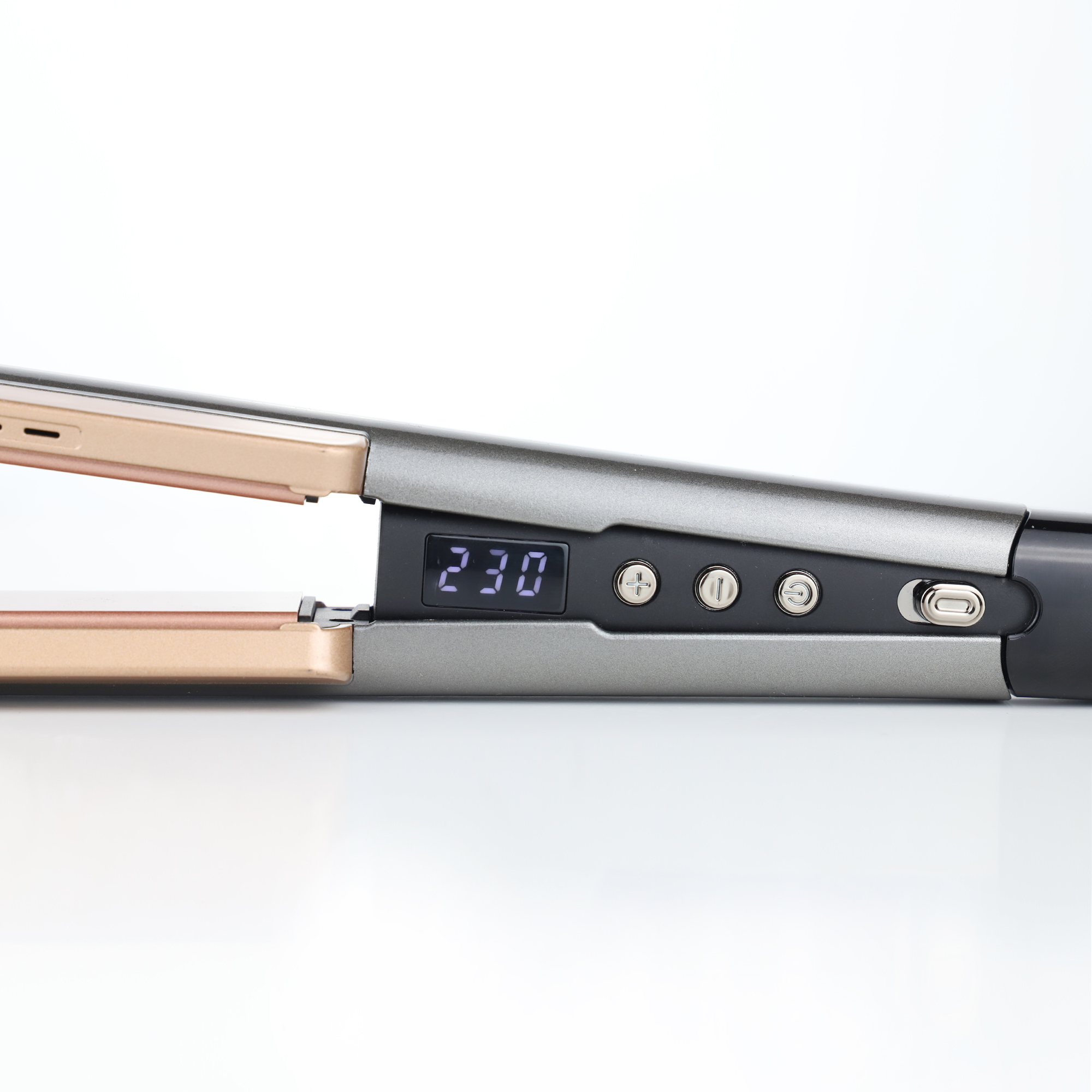 Szara i złota prostownica do włosów z cyfrowym wyświetlaczem pokazującym 230, na białym tle.